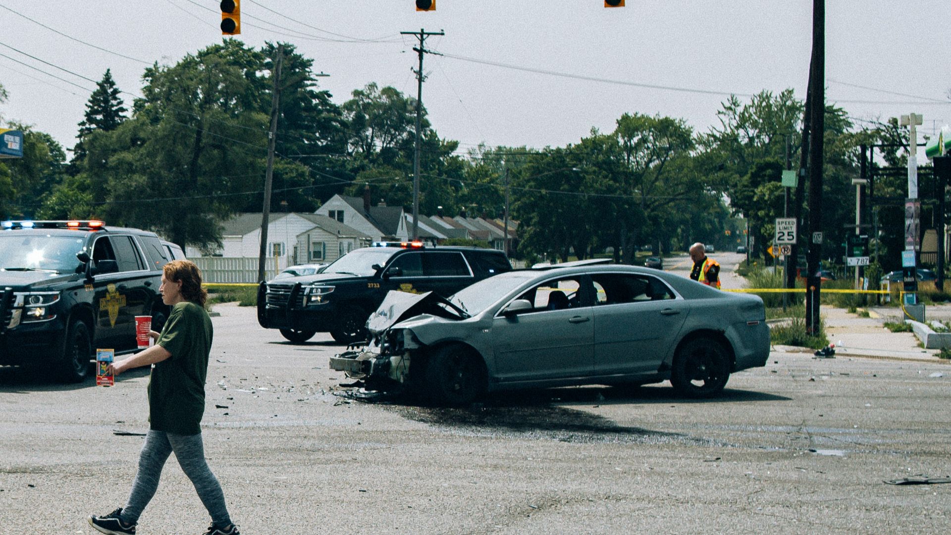 a man walking across a street next to a car