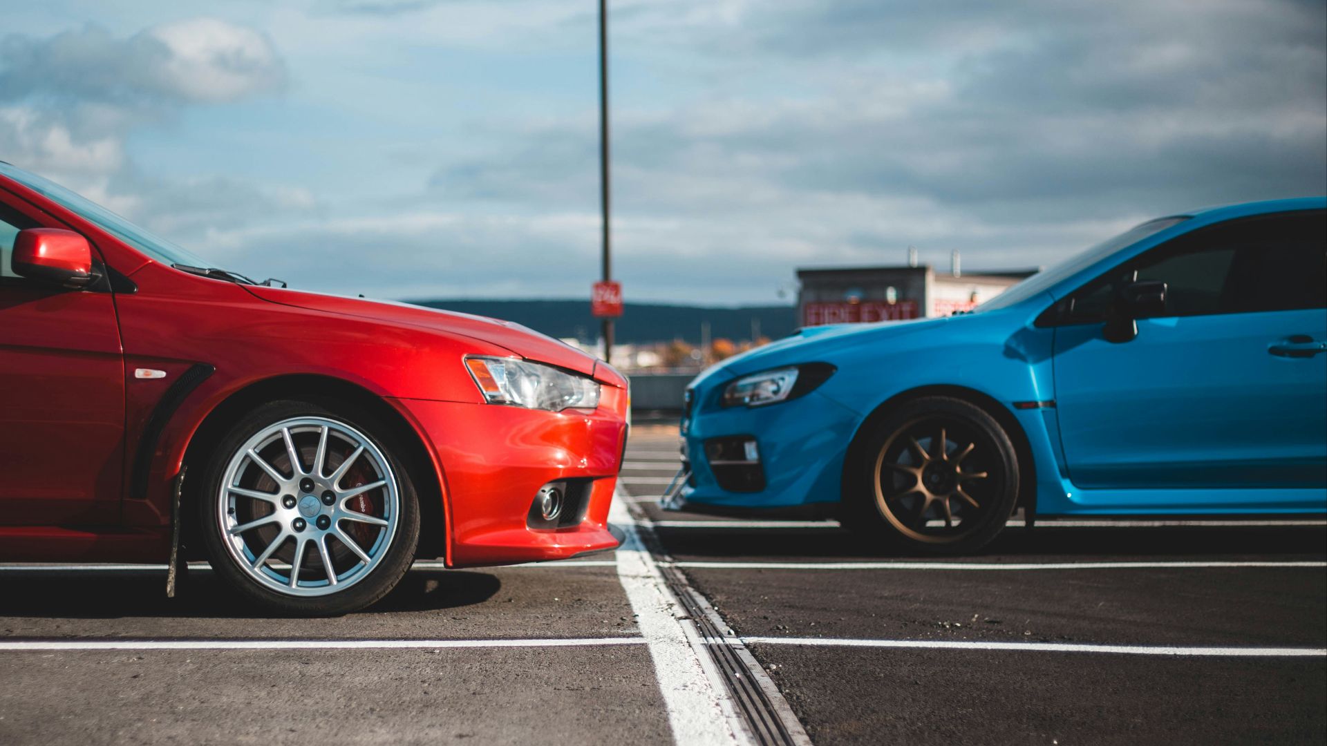 blue and red cars in parking lots