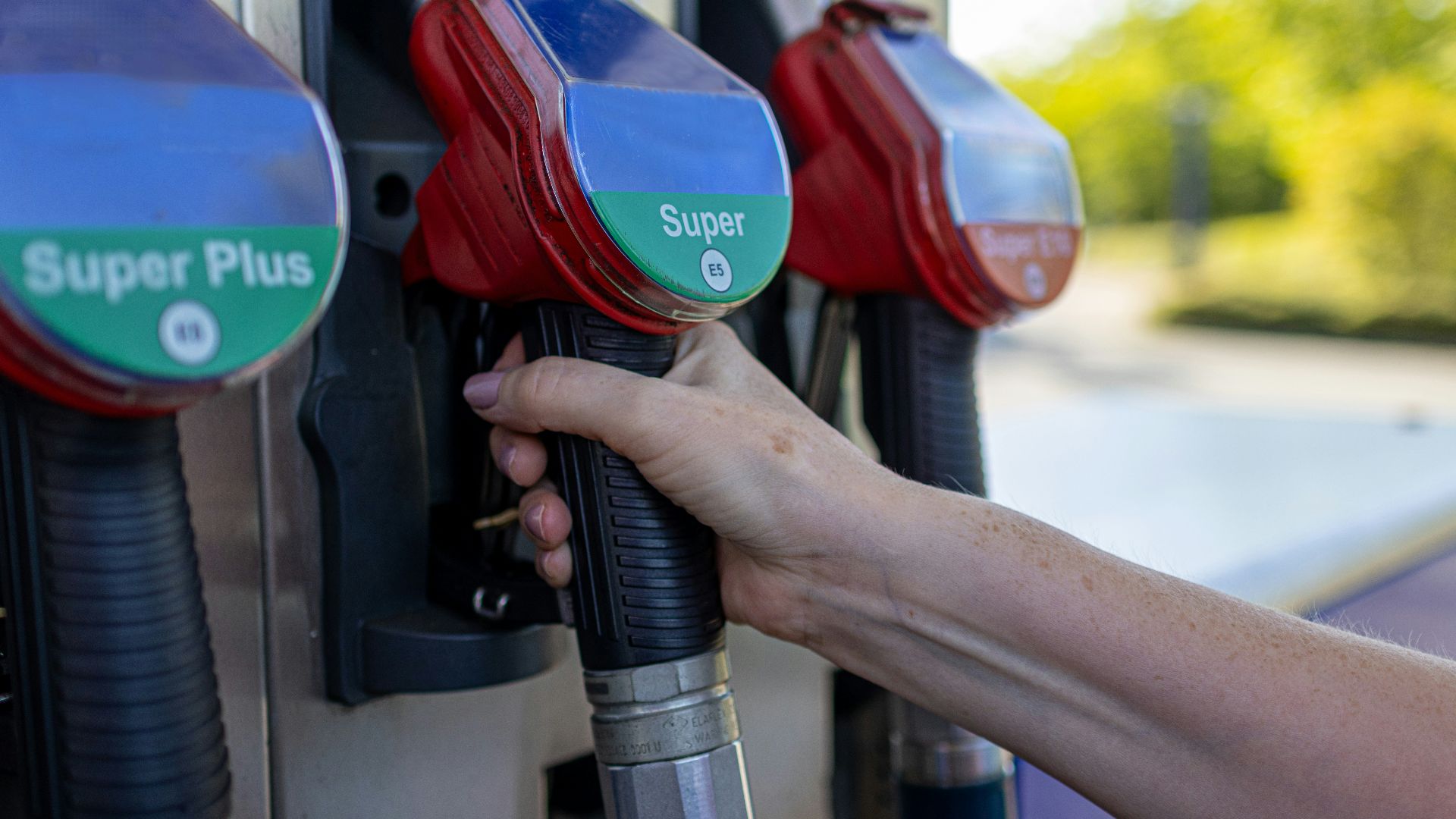a person's hand is holding a gas pump