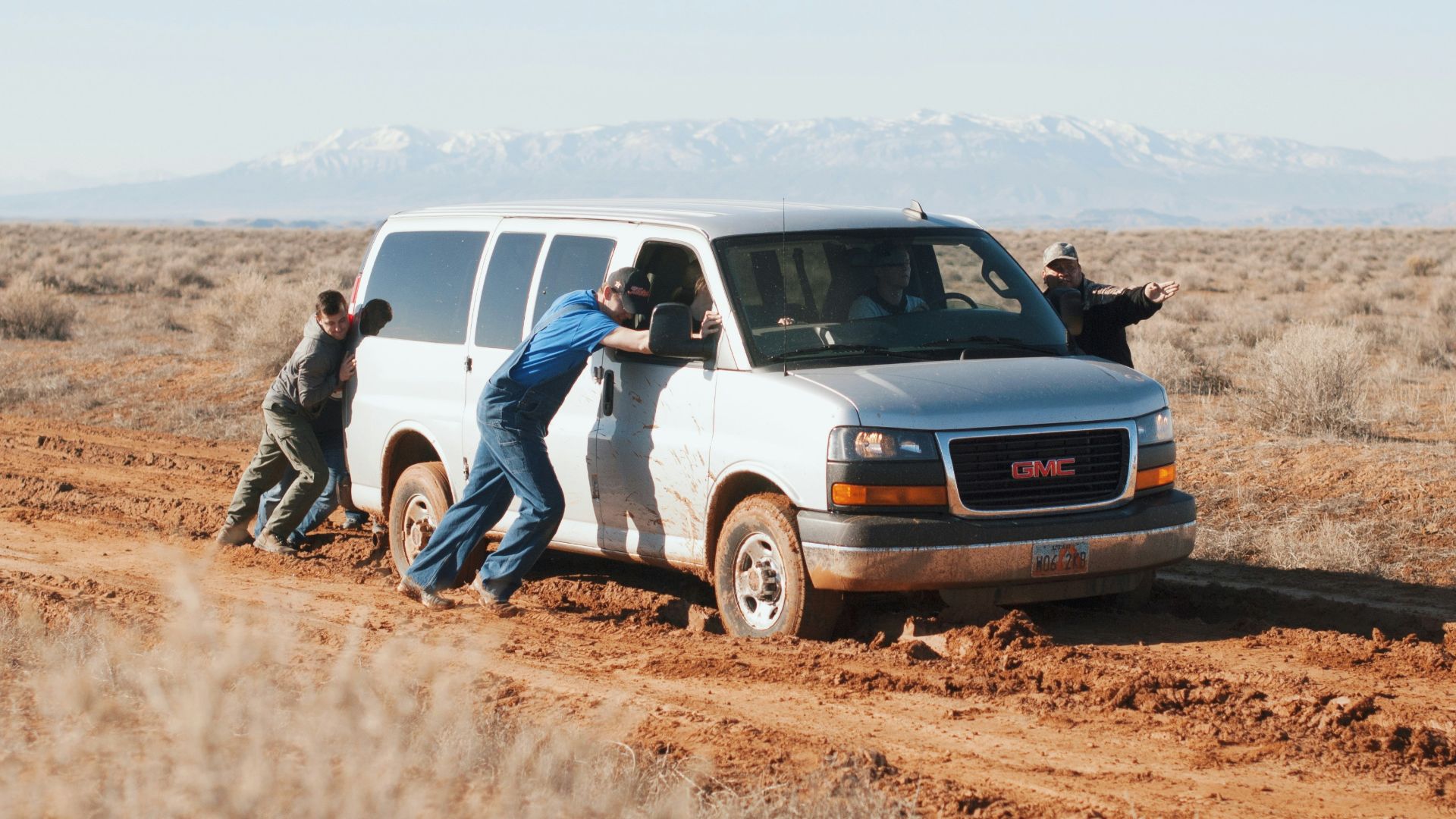 men pushing white GMC van