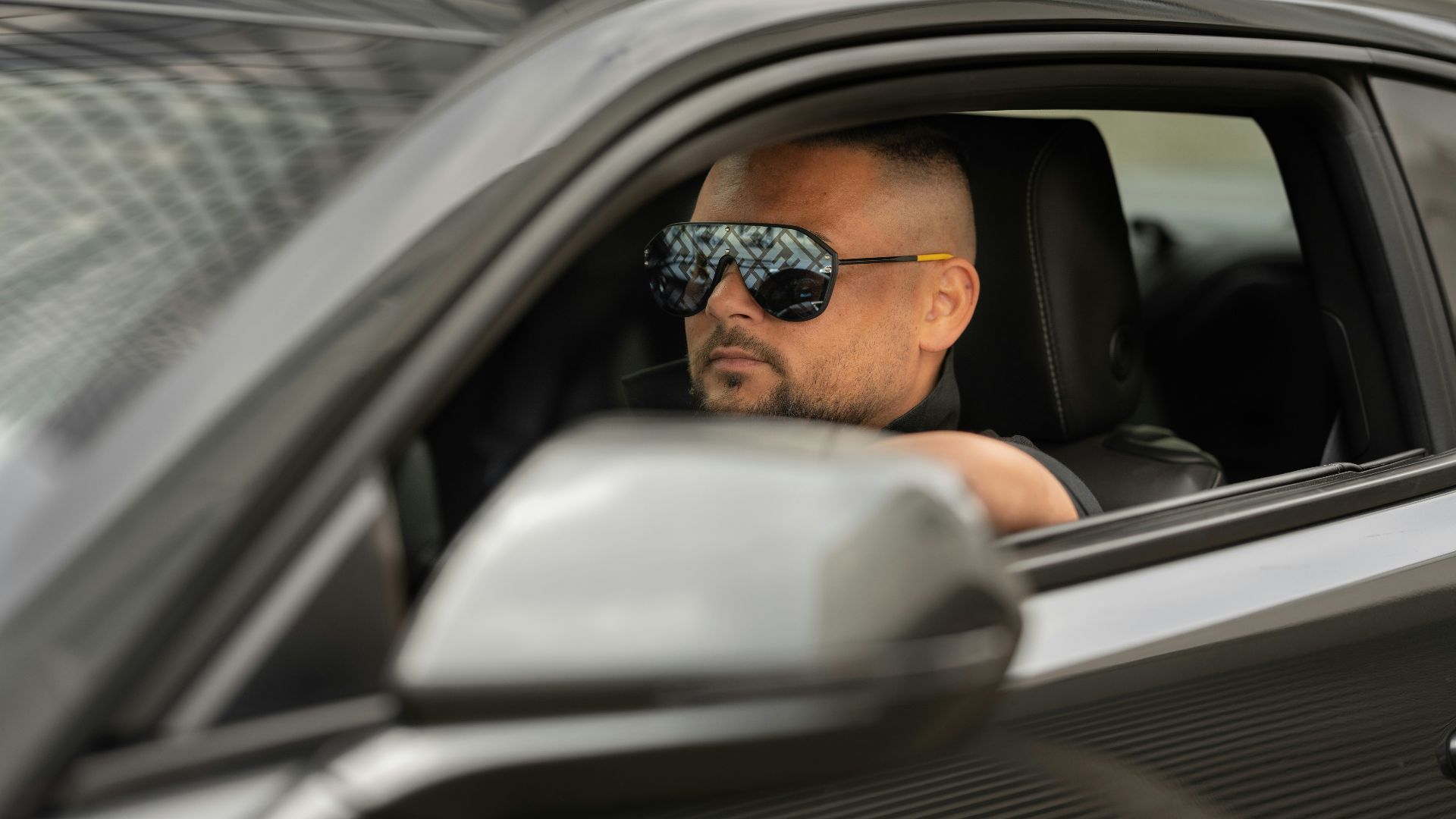 a man wearing sunglasses and sitting in a car