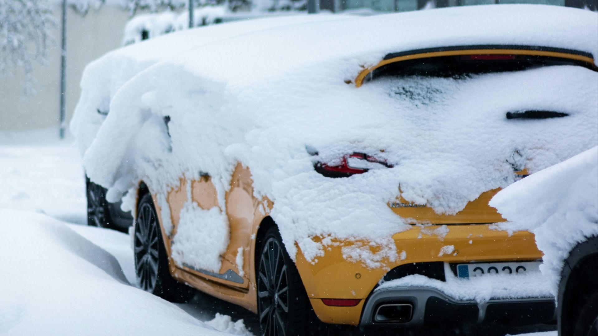 yellow car covered with snow
