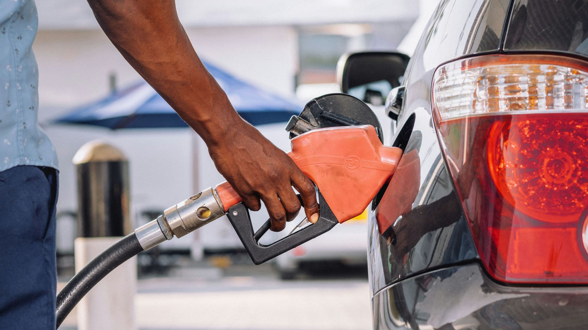 a man pumping gas into his car at a gas station