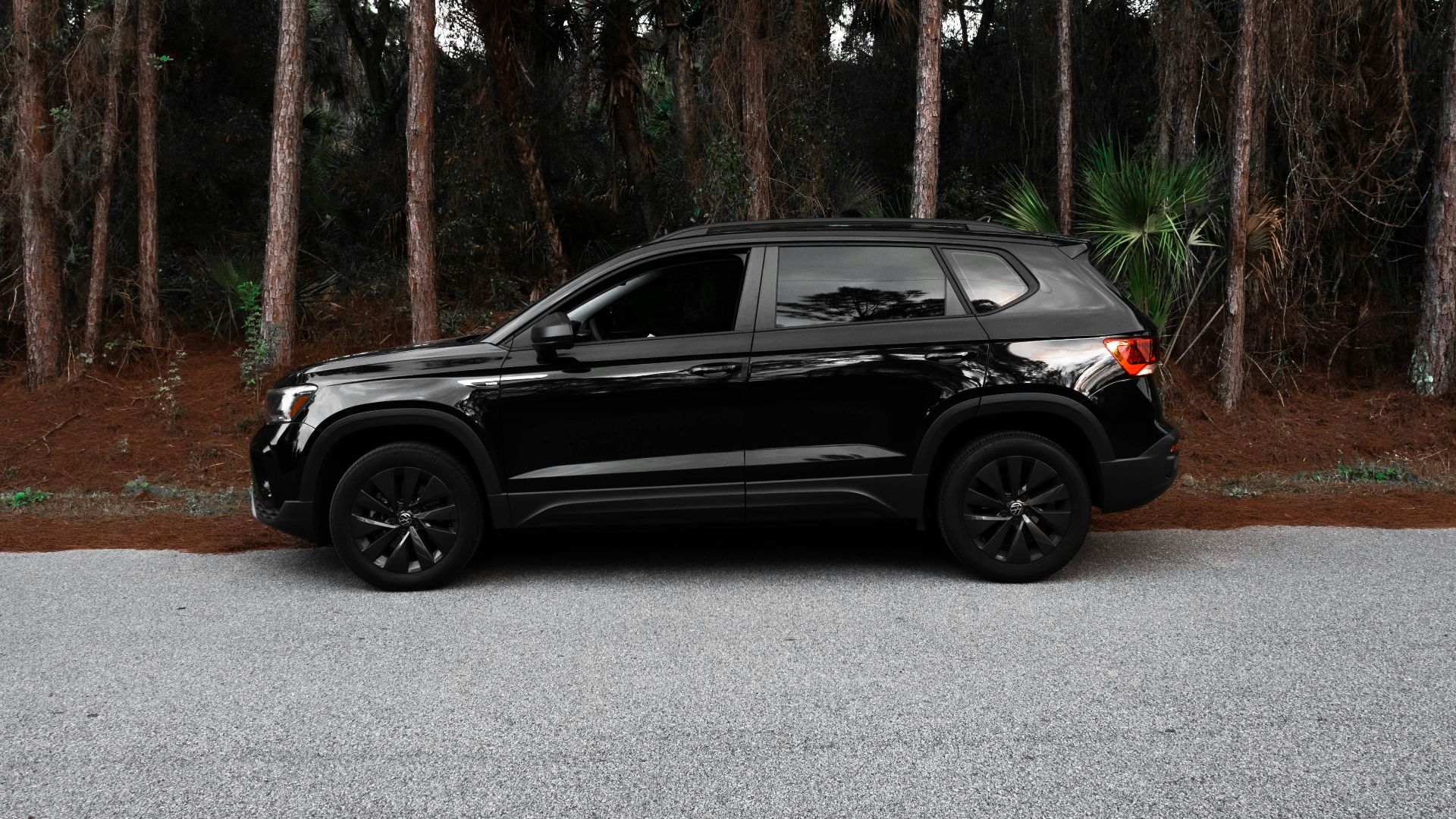 a black jeep is parked in front of some trees