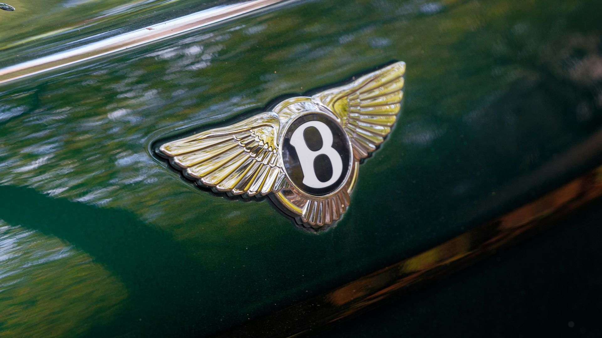 A bentley emblem on the side of a green car