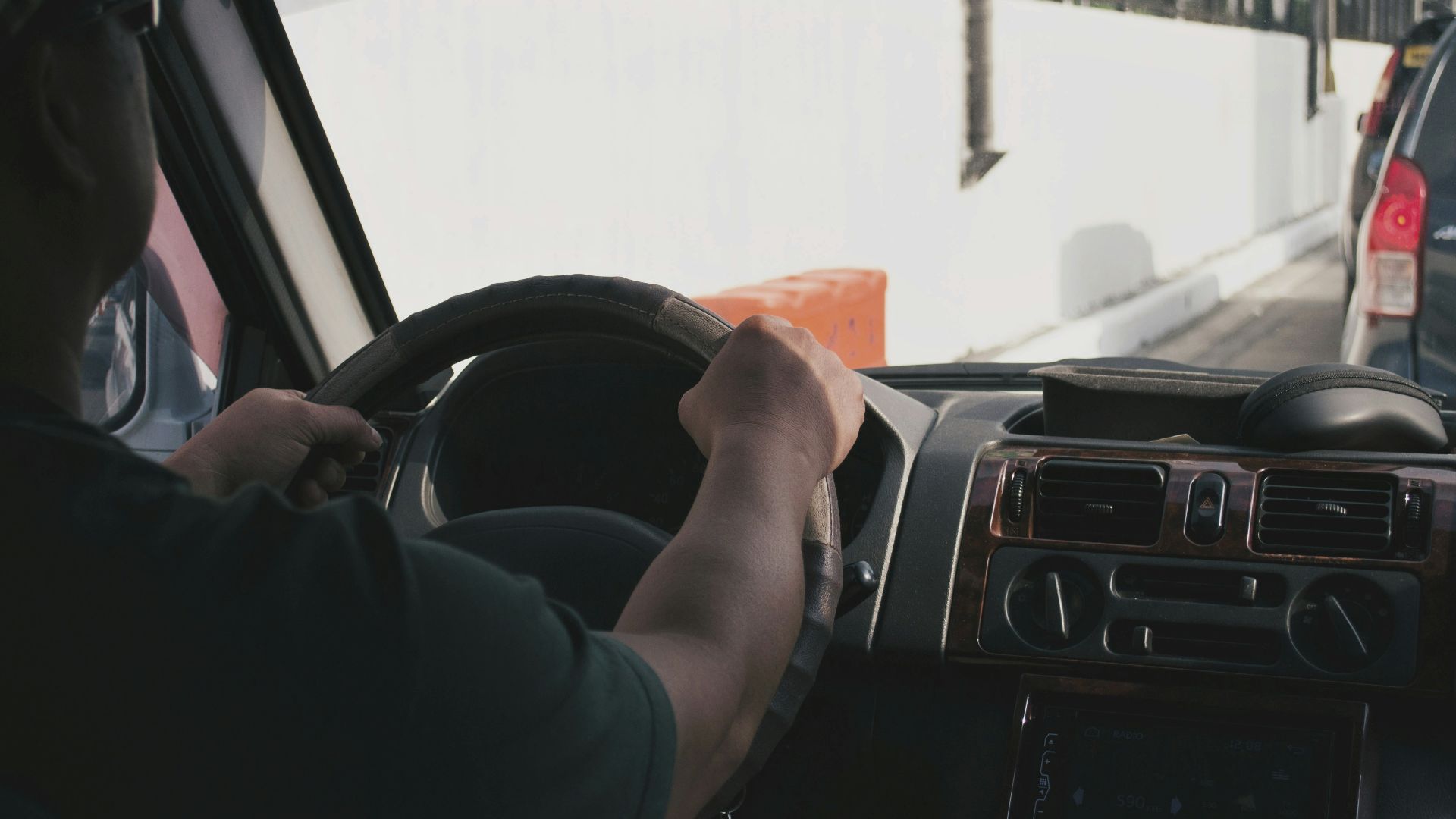 person driving vehicle on road near vehicle at daytime