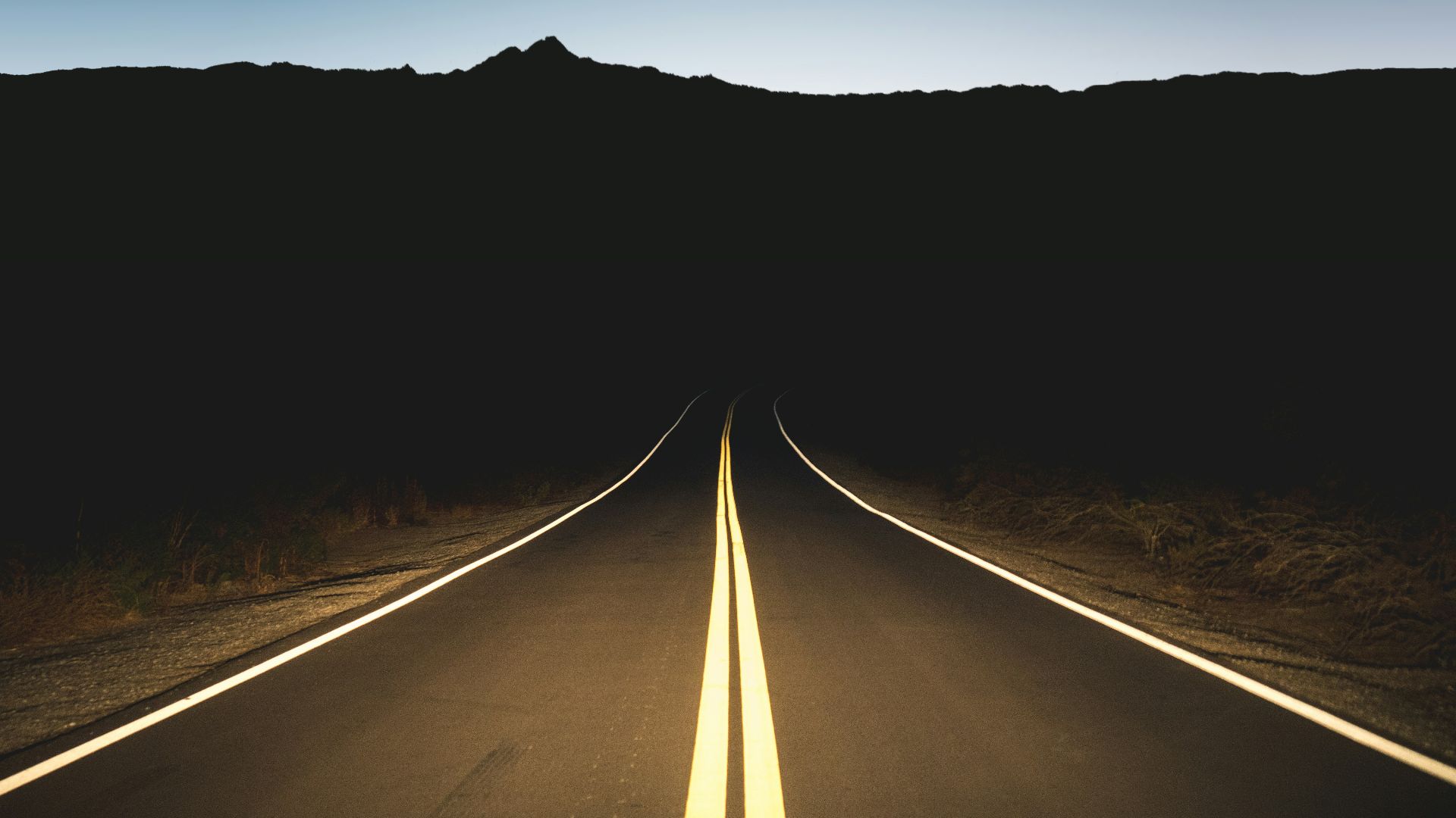 a long straight road with trees on either side of it
