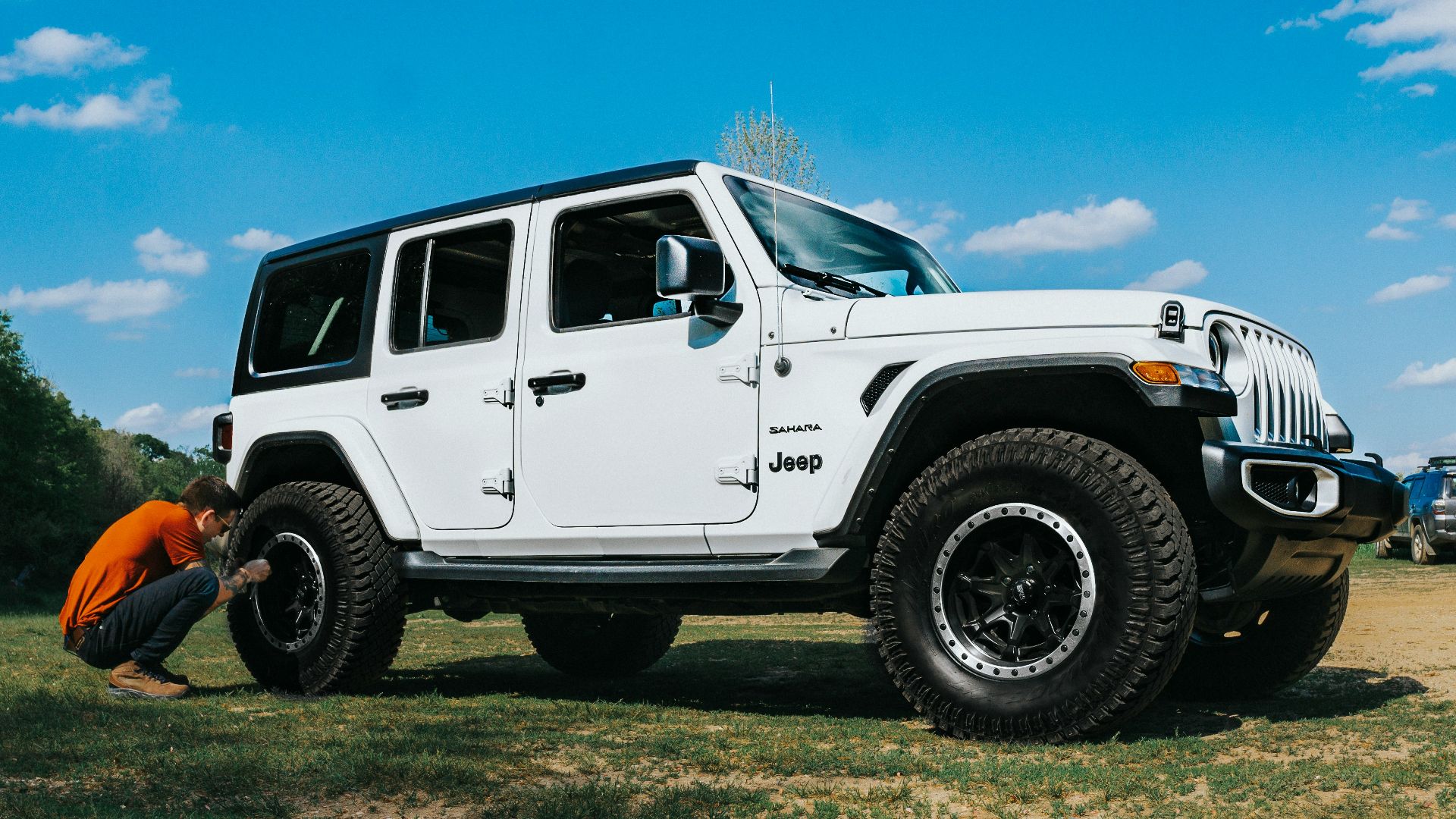 white suv on green grass field under blue sky during daytime