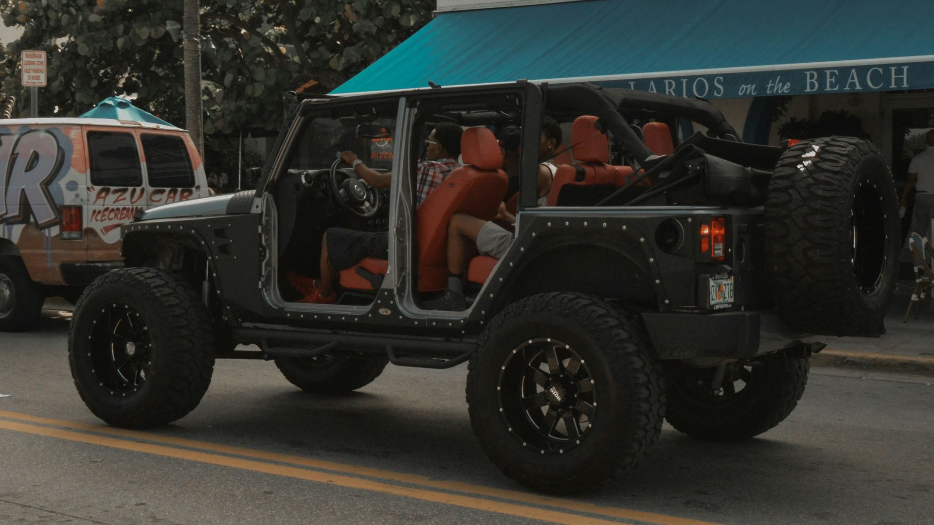 a jeep driving down a street next to a building