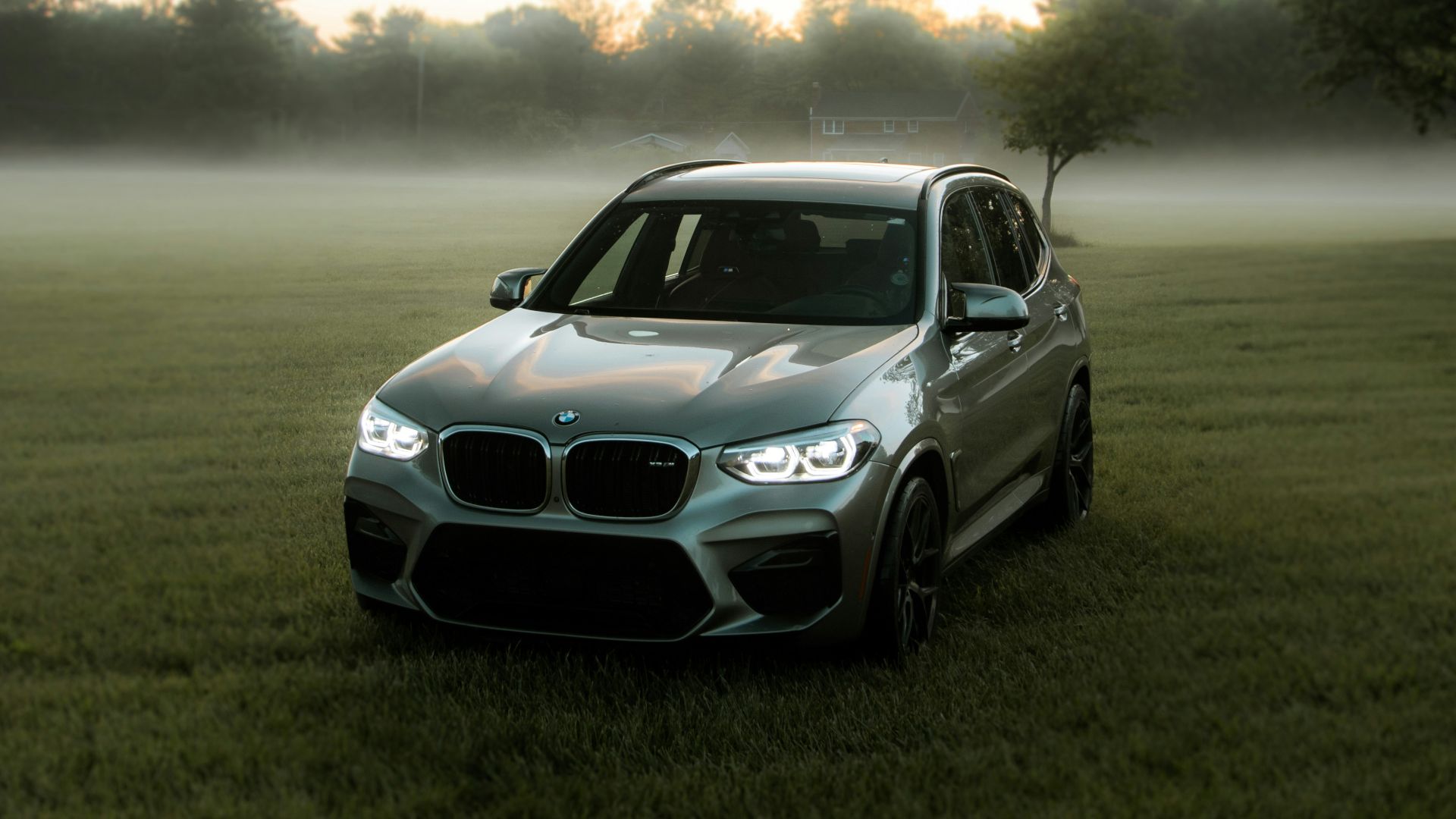a silver car parked on top of a lush green field