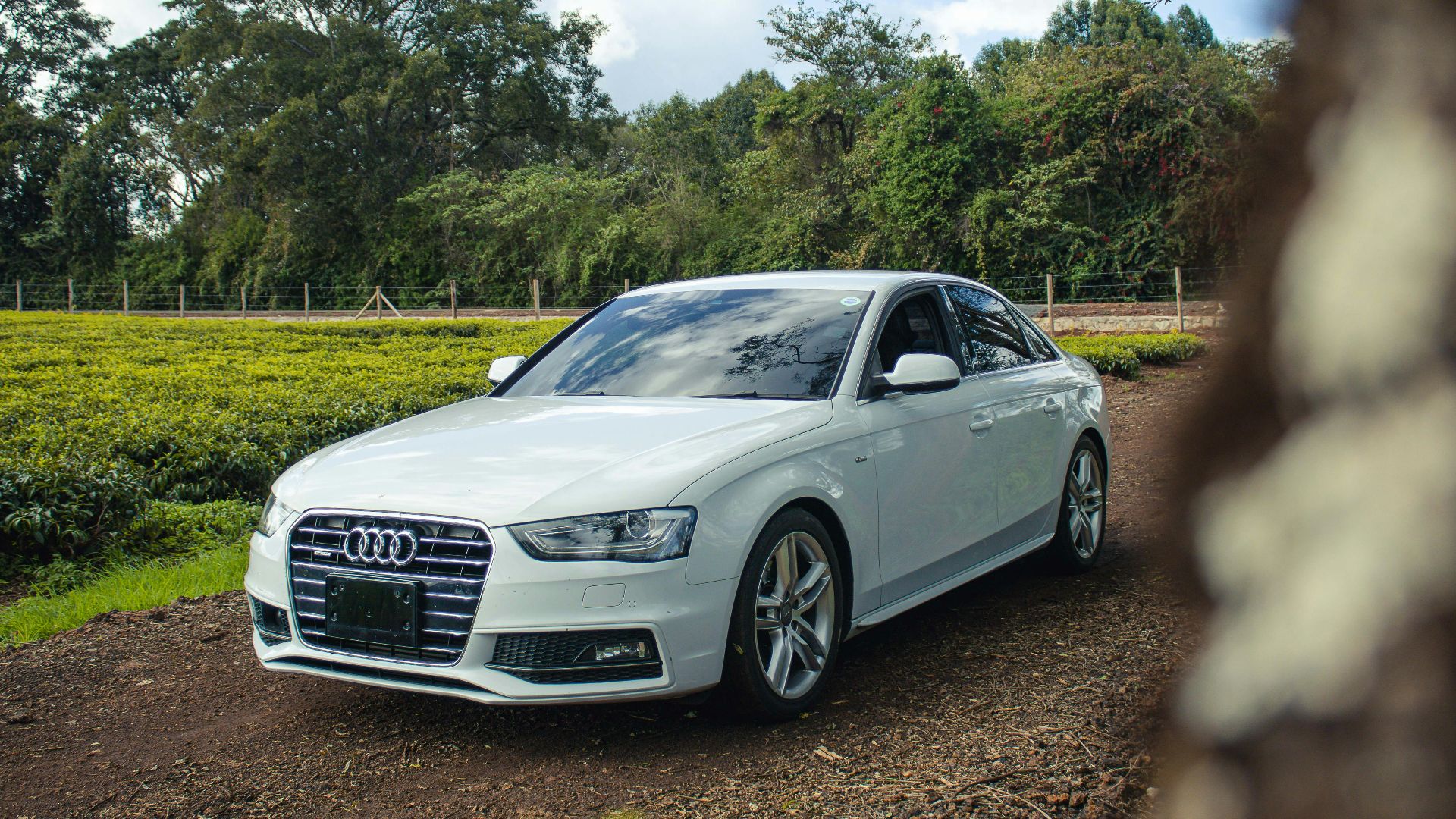 A white car parked on a dirt road