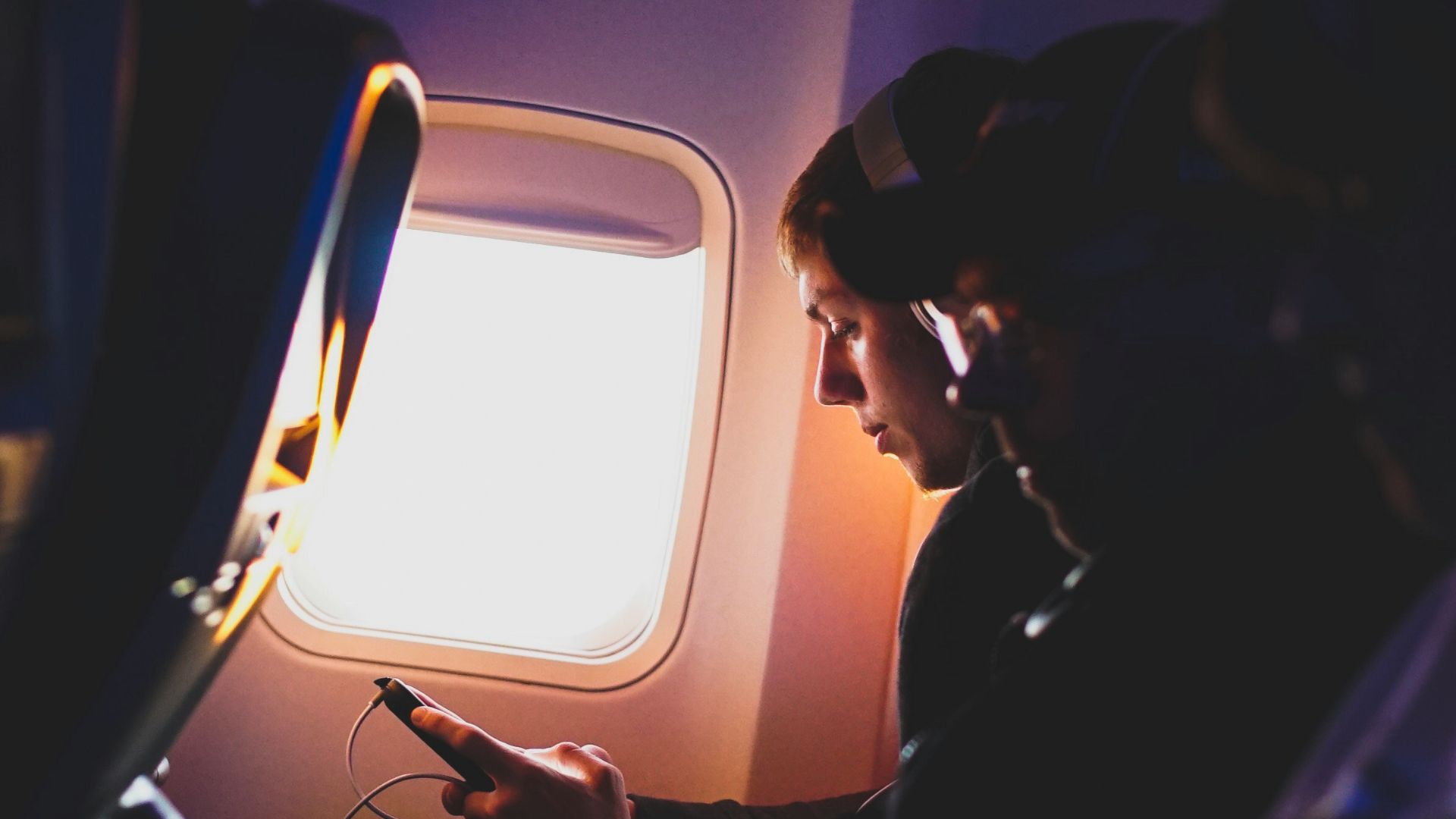 photo of three people listening to music inside airplane