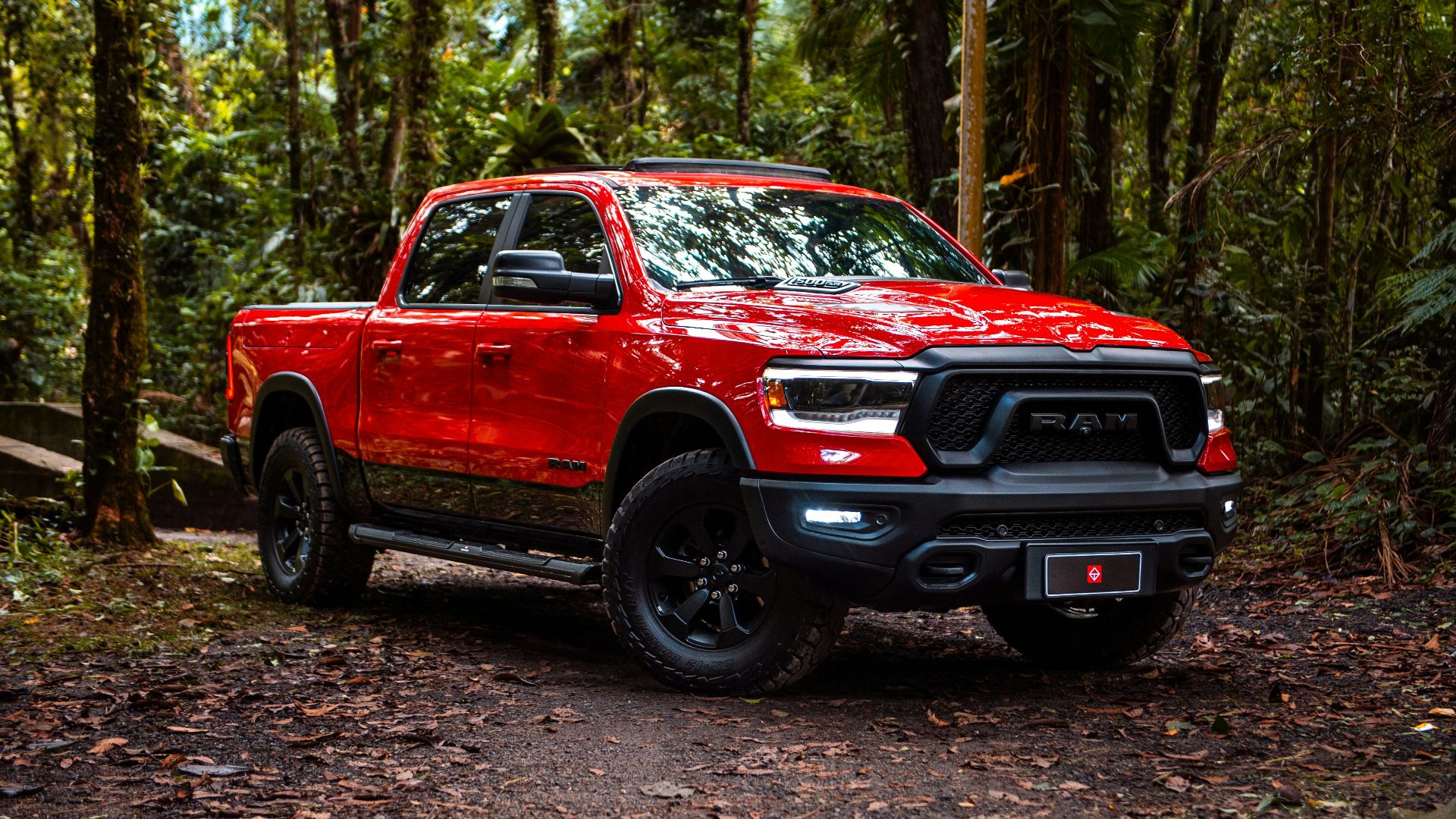 Red truck is parked in a forest.