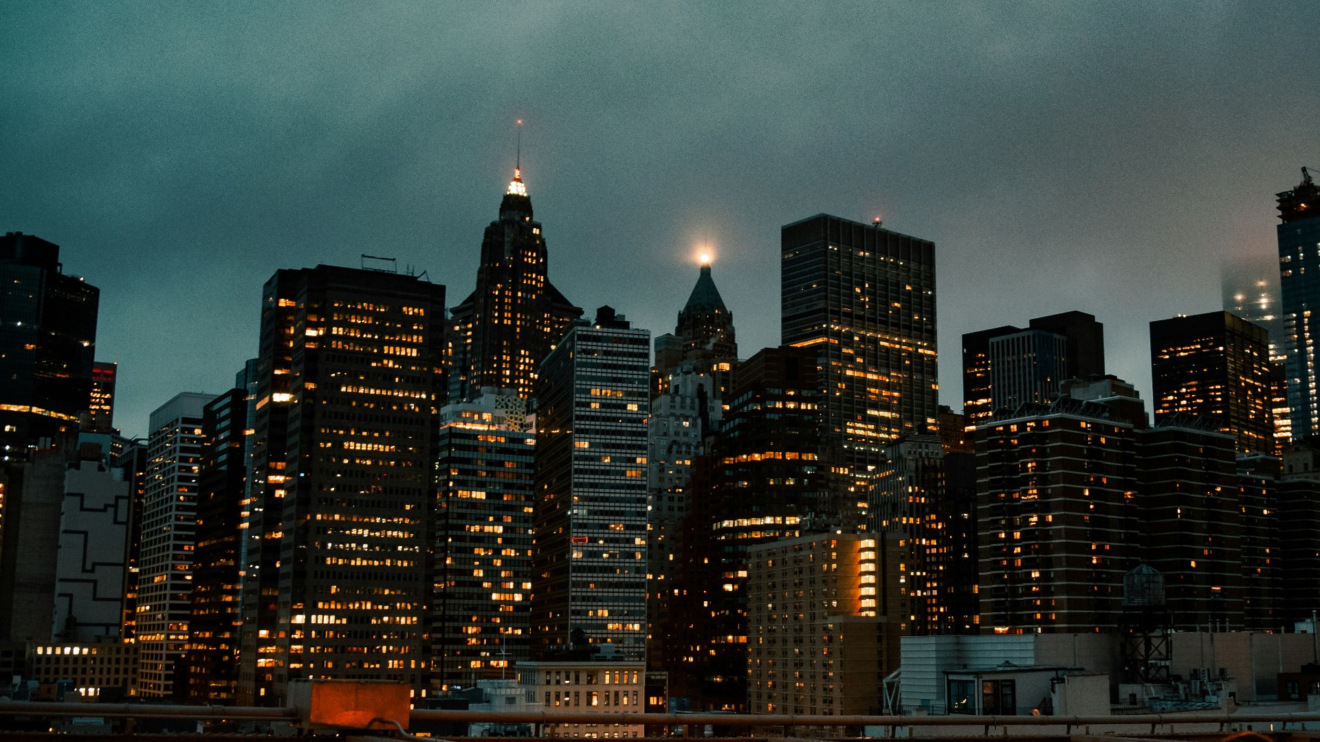 man in white shirt sitting on red metal bridge during night time