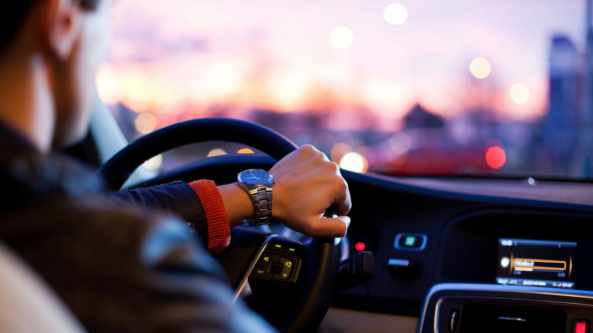 man driving a car wearing wrist watch