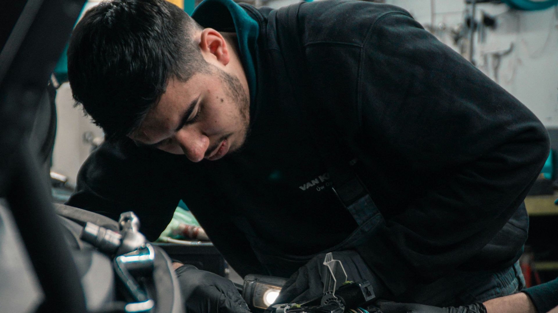 man in black jacket and blue denim jeans riding motorcycle