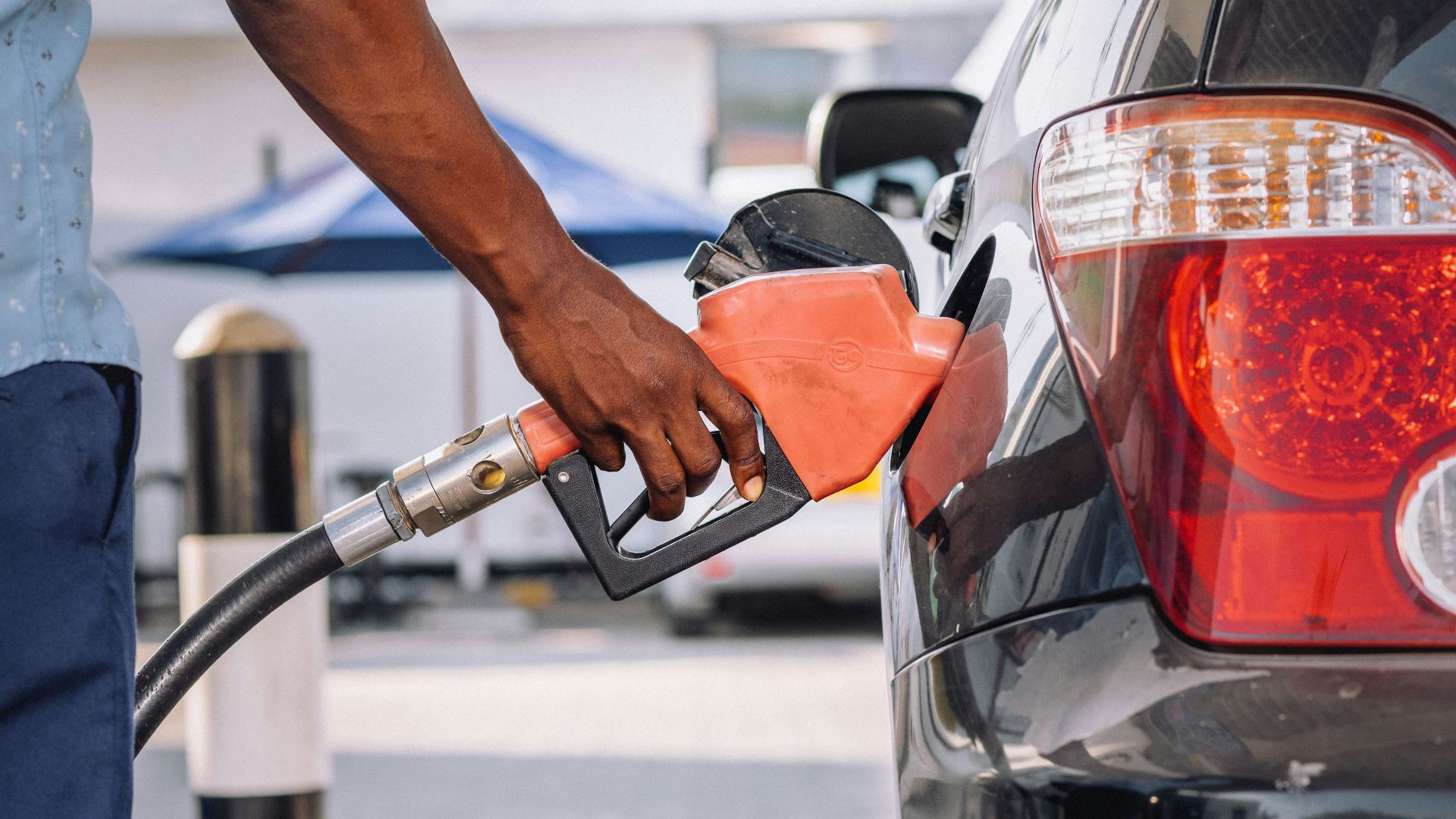 a man pumping gas into his car at a gas station