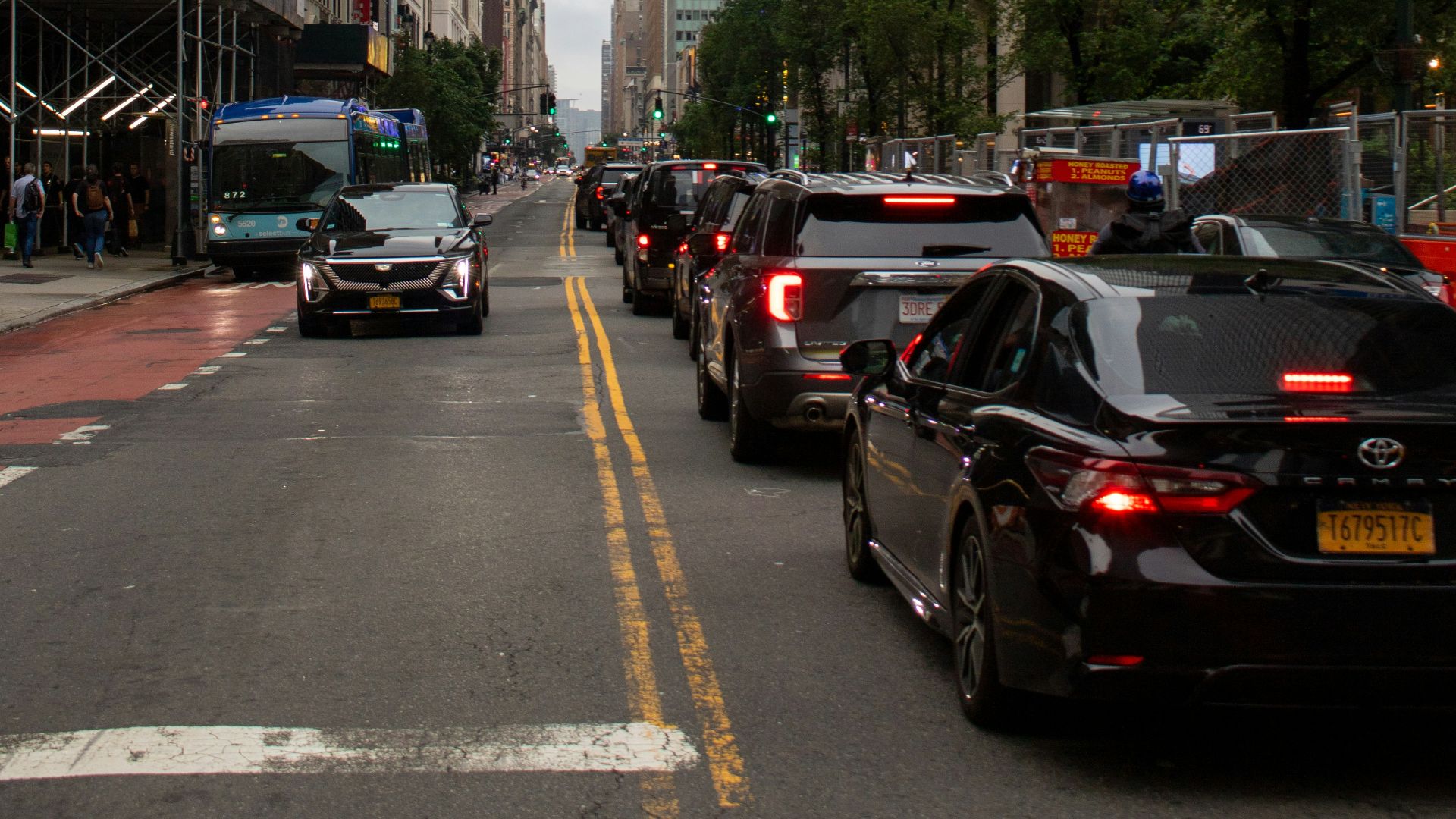 A city street filled with traffic next to tall buildings
