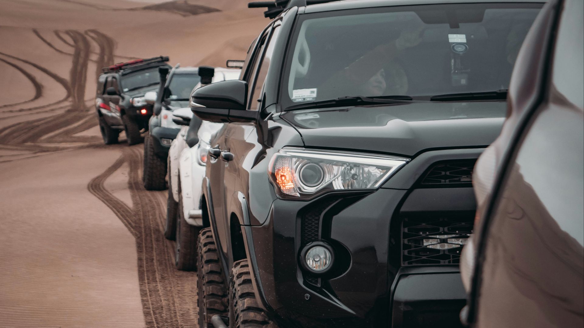 black SUV running on dune san