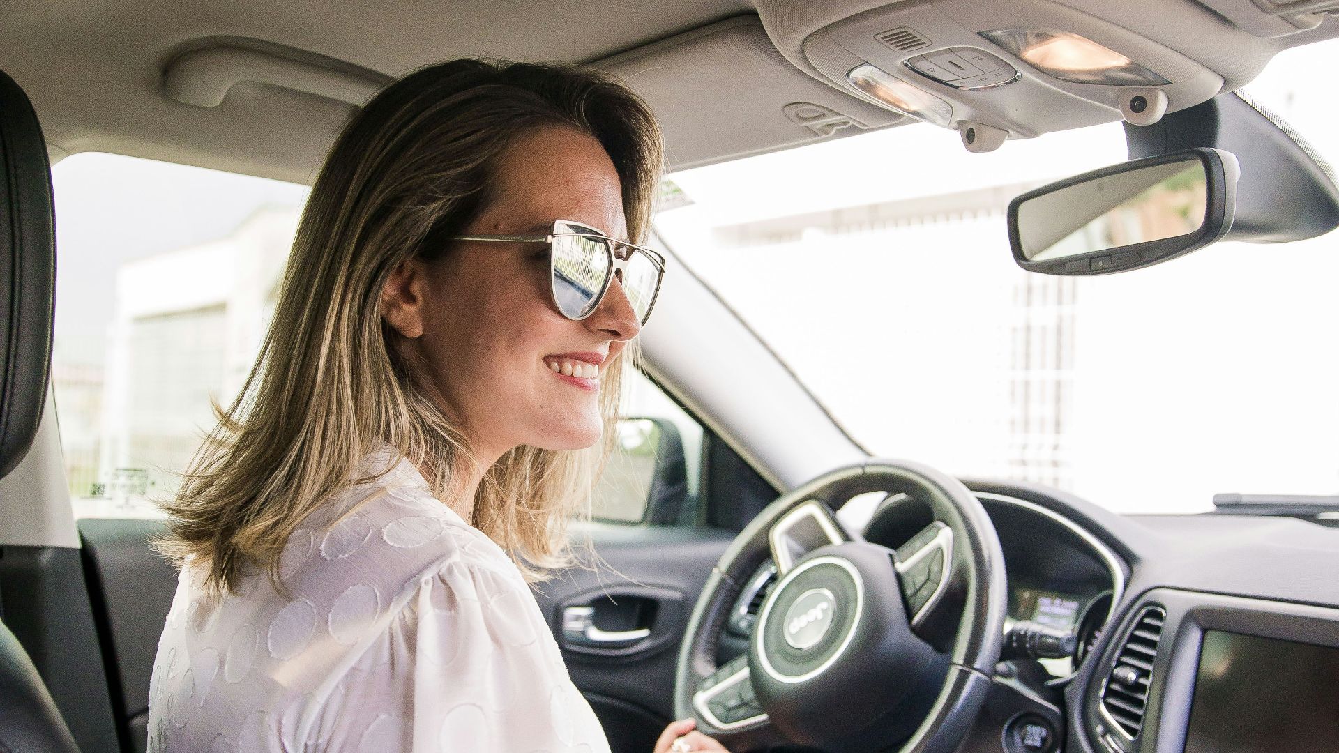 woman in white long sleeve shirt driving car
