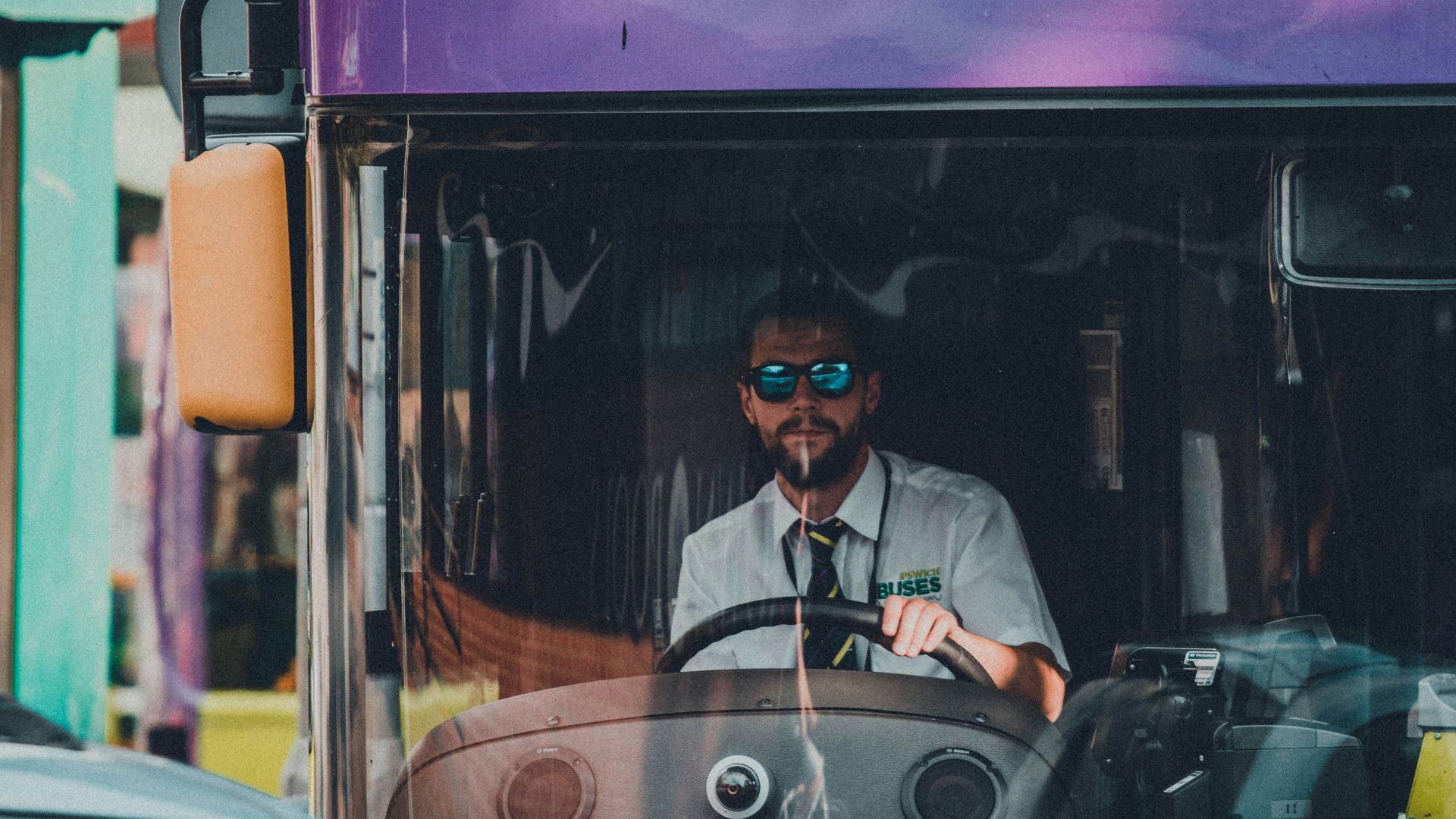 man in black jacket sitting on red bus during night time