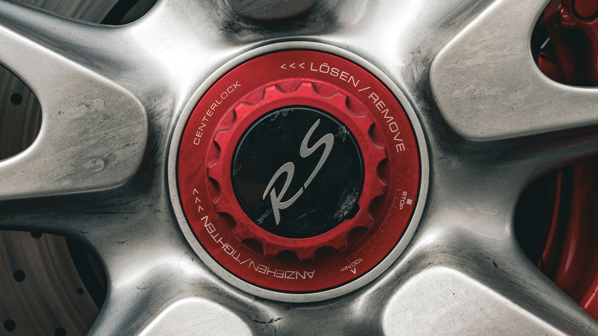 Close-up of a silver car wheel with red accents.