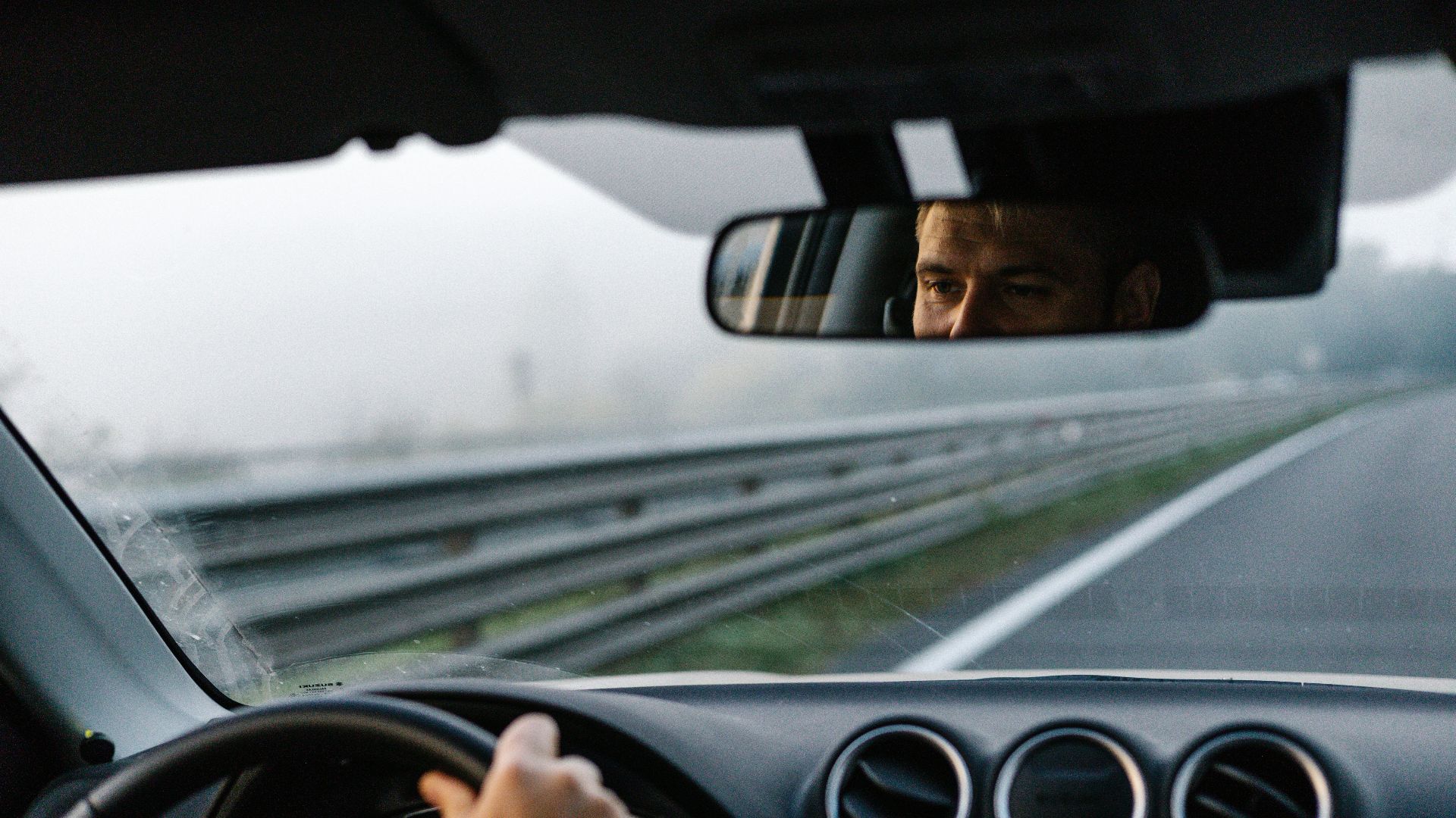 a man driving a car on a highway