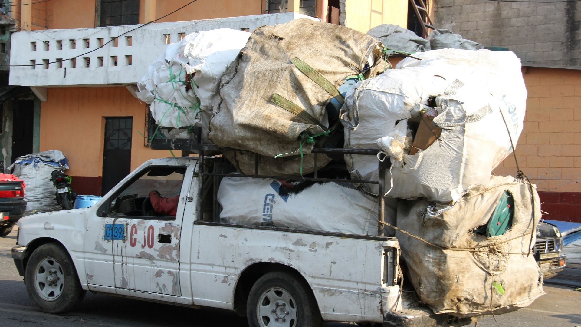 a white truck with a bunch of bags on the back of it