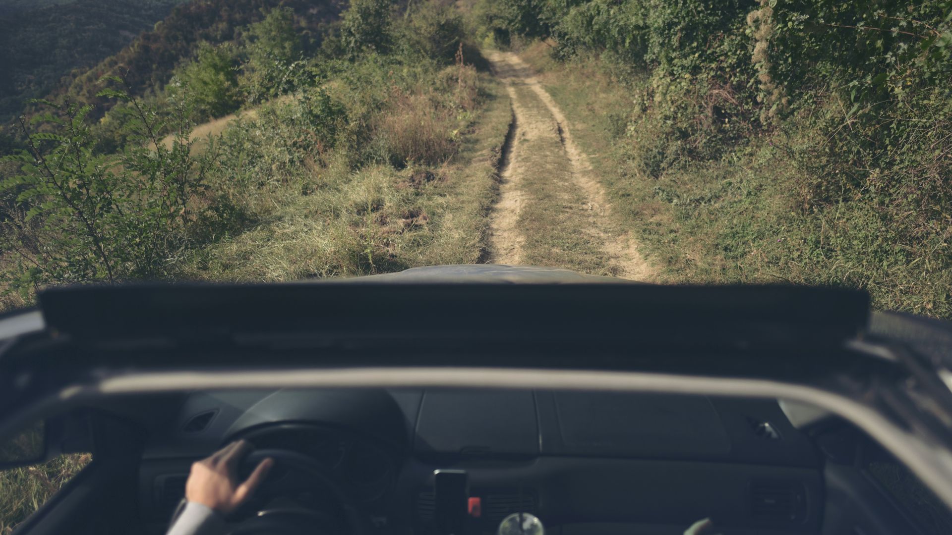 a person driving a car down a dirt road