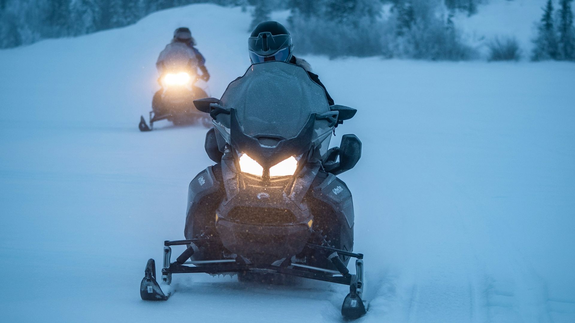 two persons riding snowmobile