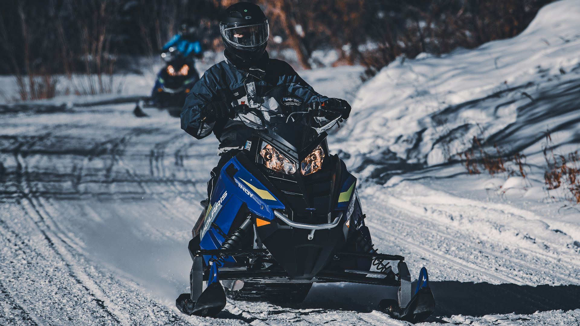 two people riding on a snowmobile in the snow