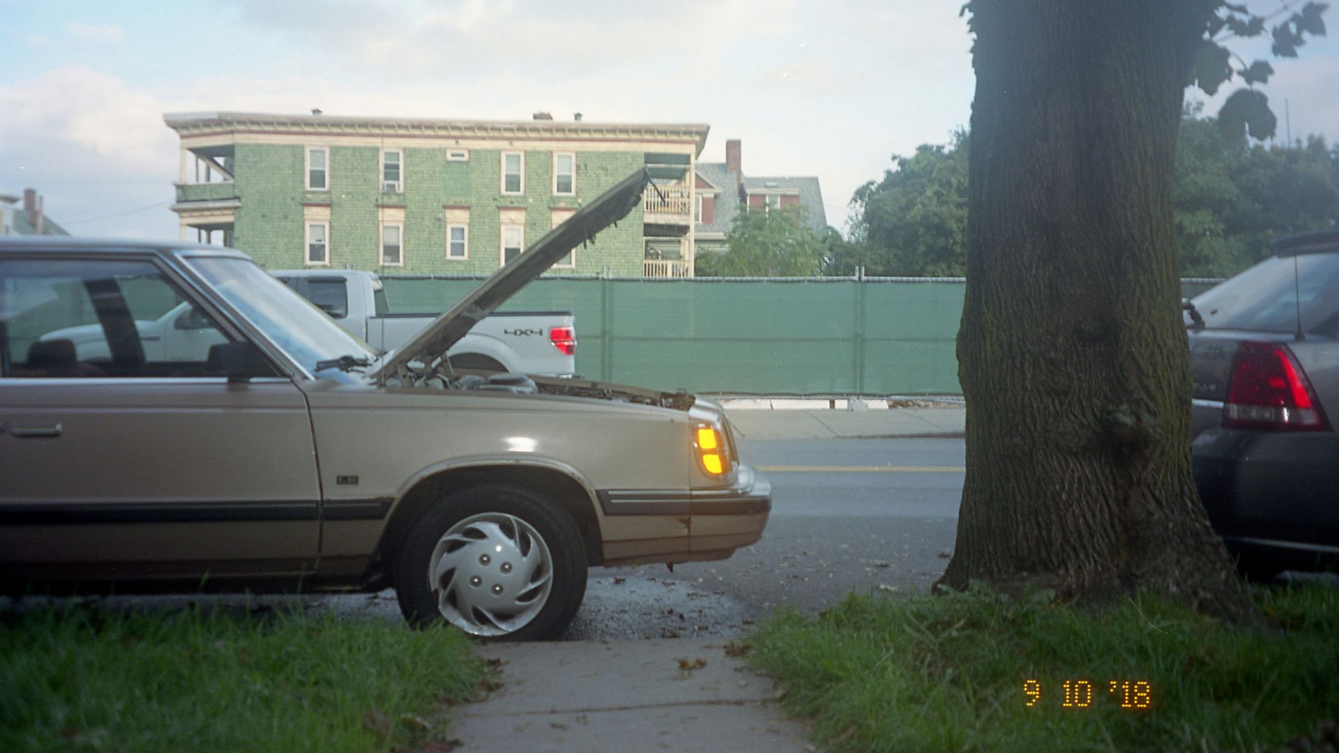 silver sedan parked on sidewalk during daytime