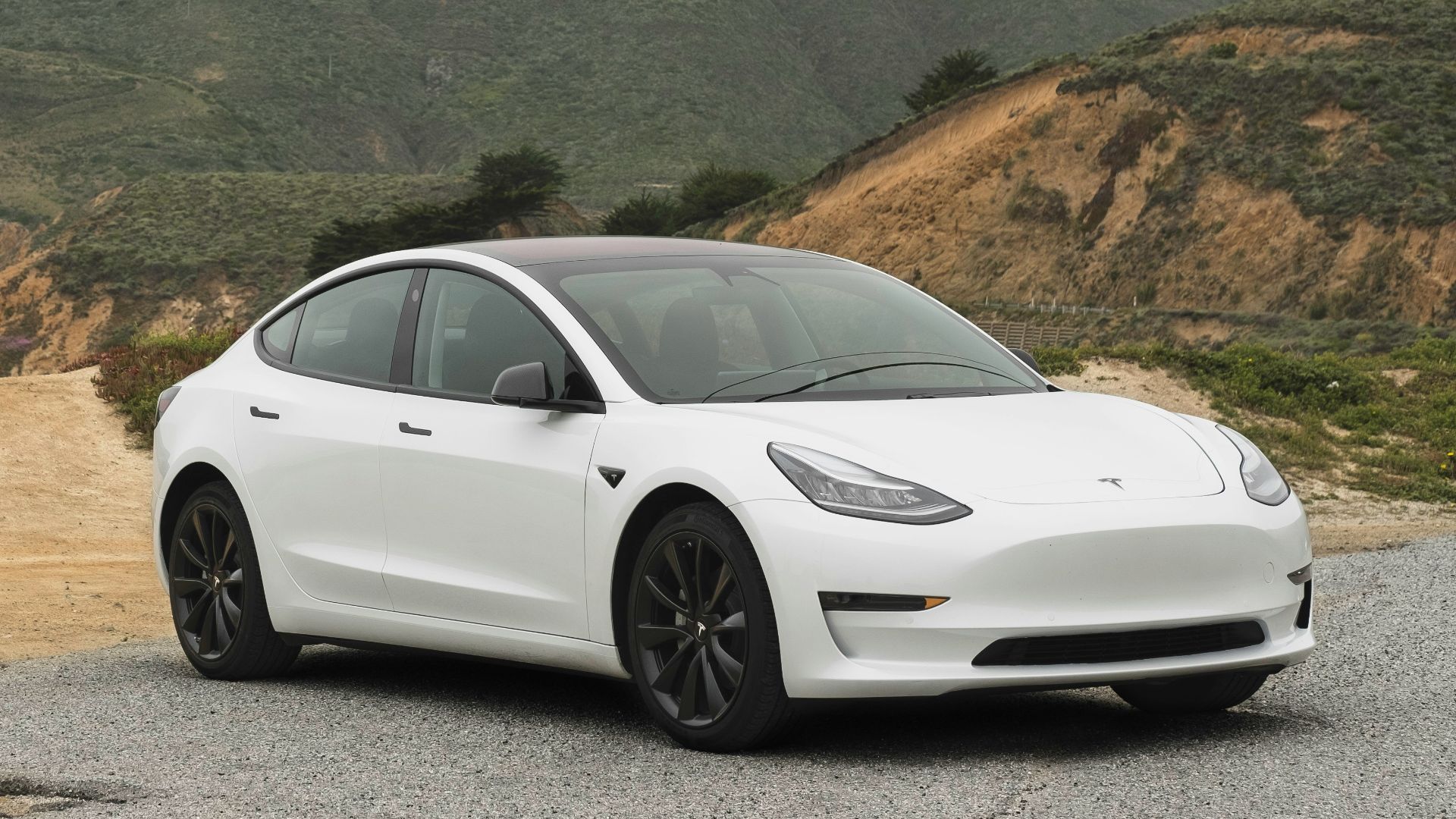 white sedan parked beside mountain during daytime