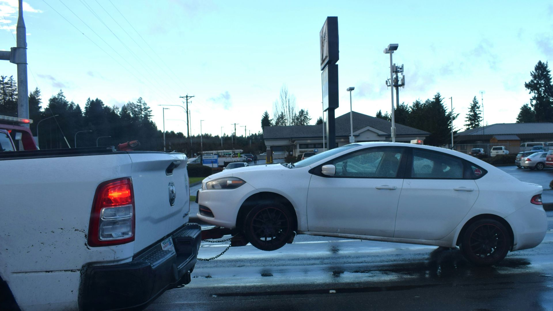 a white car being towed by a tow truck