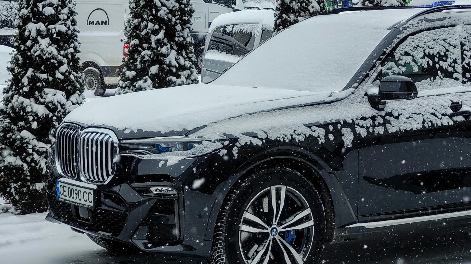 a car is covered in snow in a parking lot