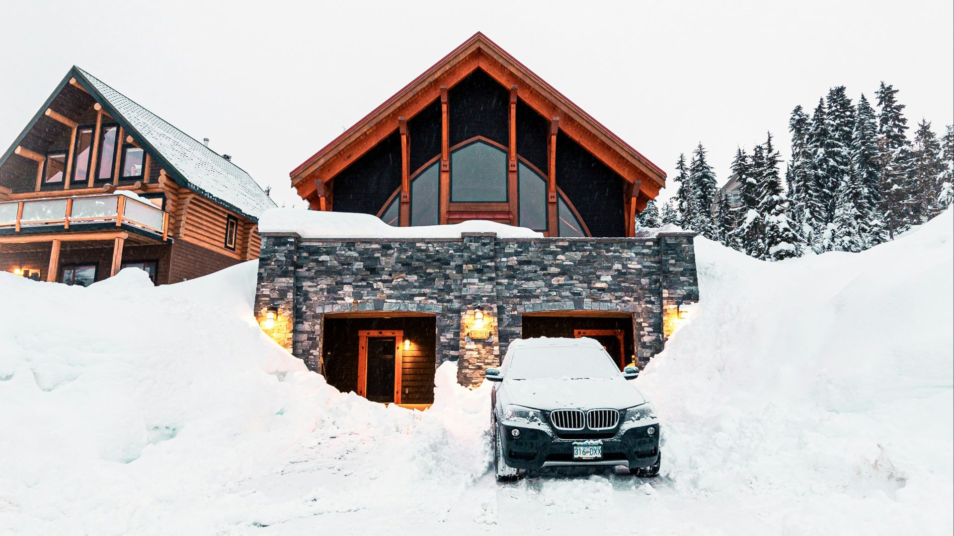 Modern house buried in deep snow with car.