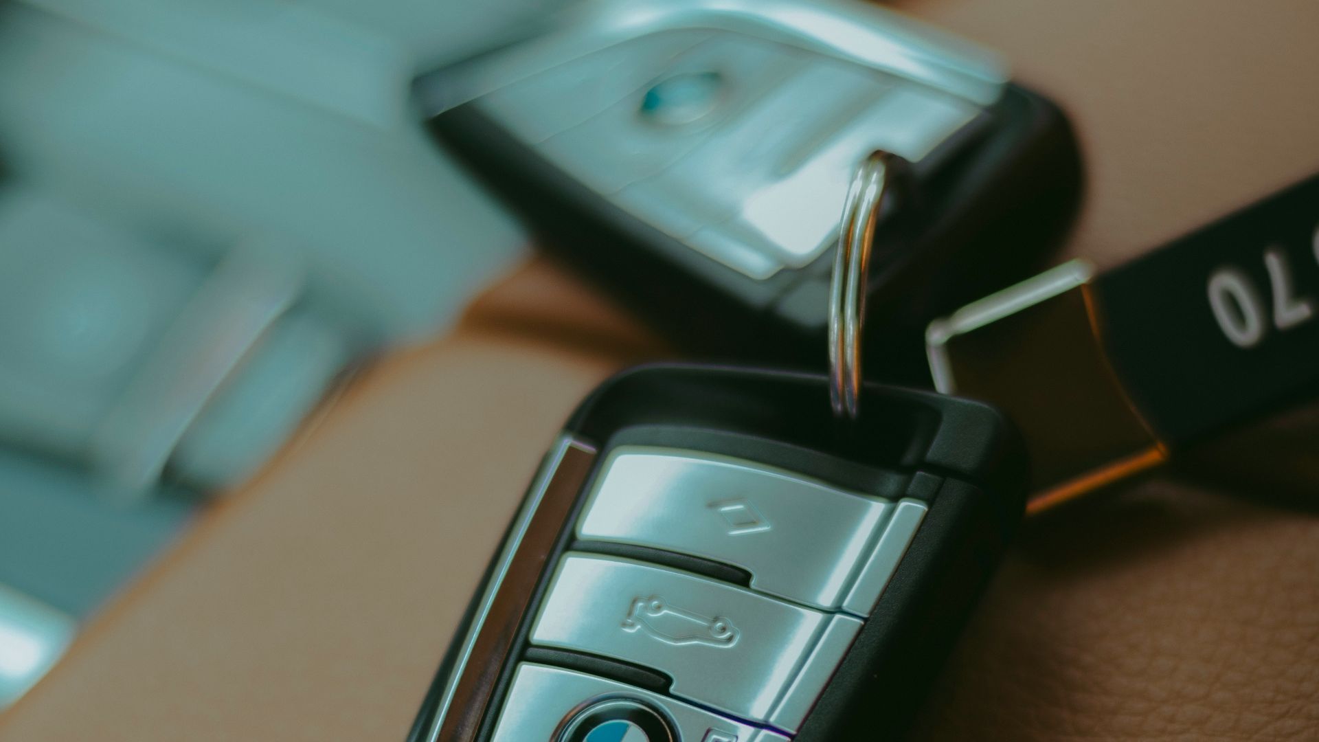 Two BMW car keys resting on leather seats.
