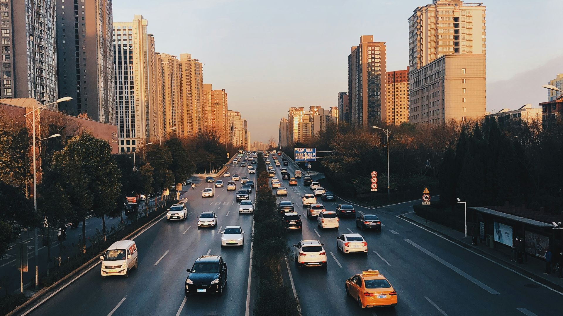 a city street filled with lots of traffic next to tall buildings