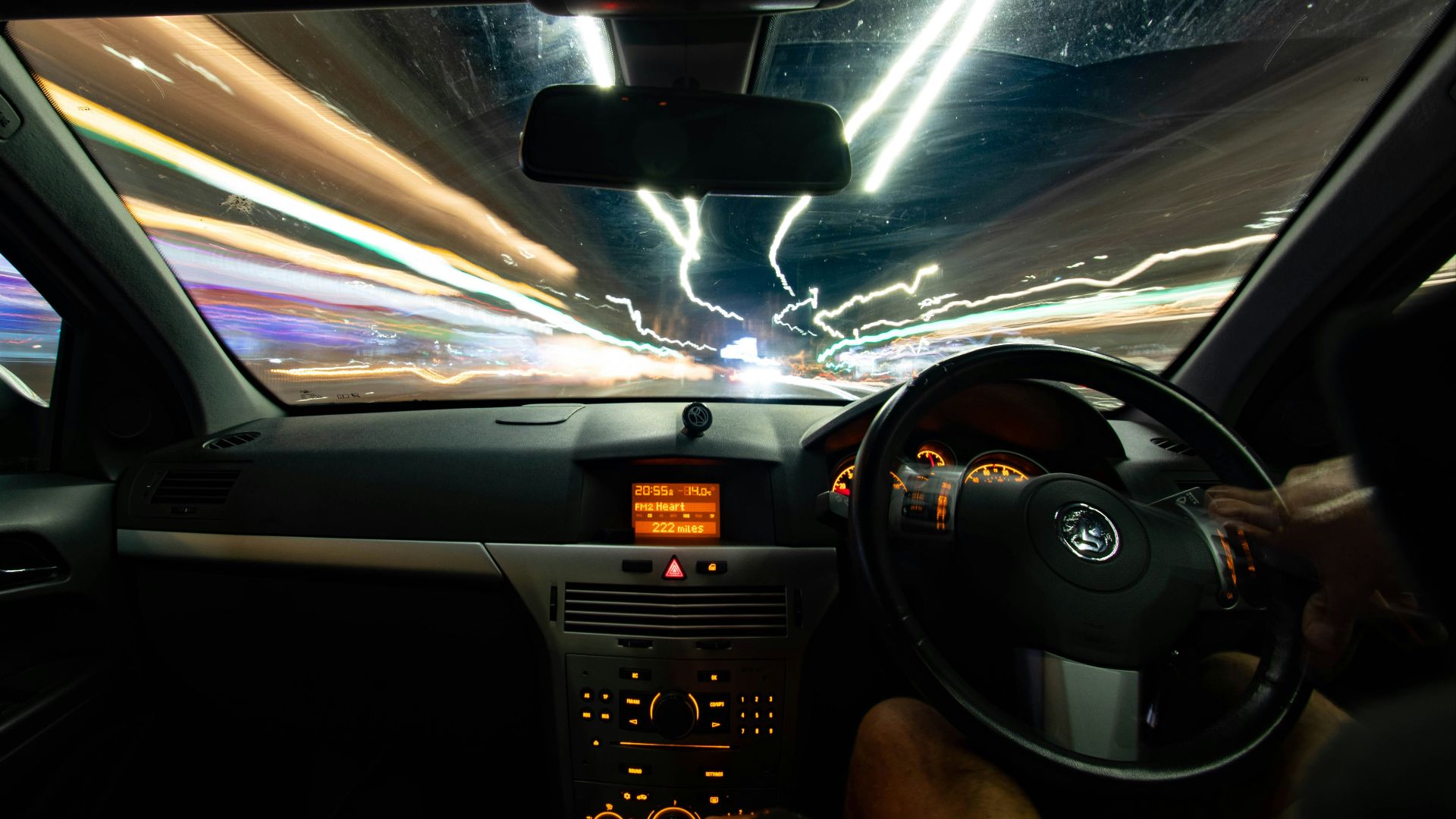 a car driving down a street at night