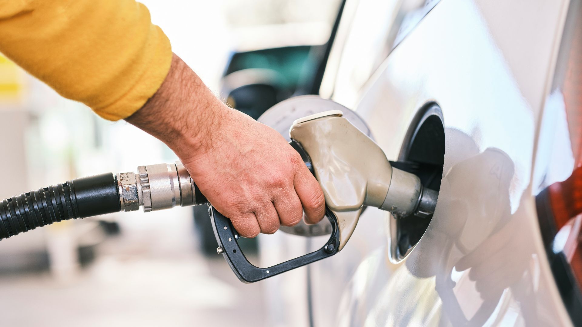 a man pumping gas into his car at a gas station