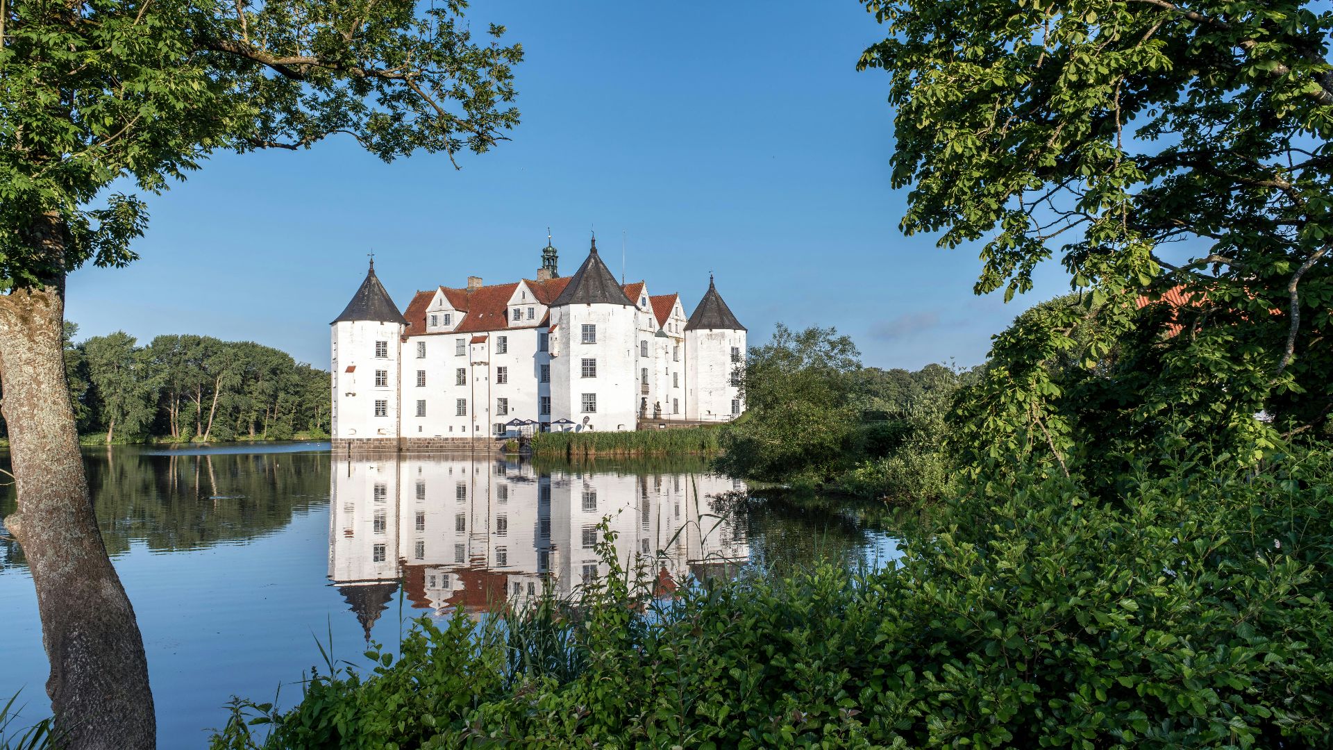 A large white castle sitting on top of a lake