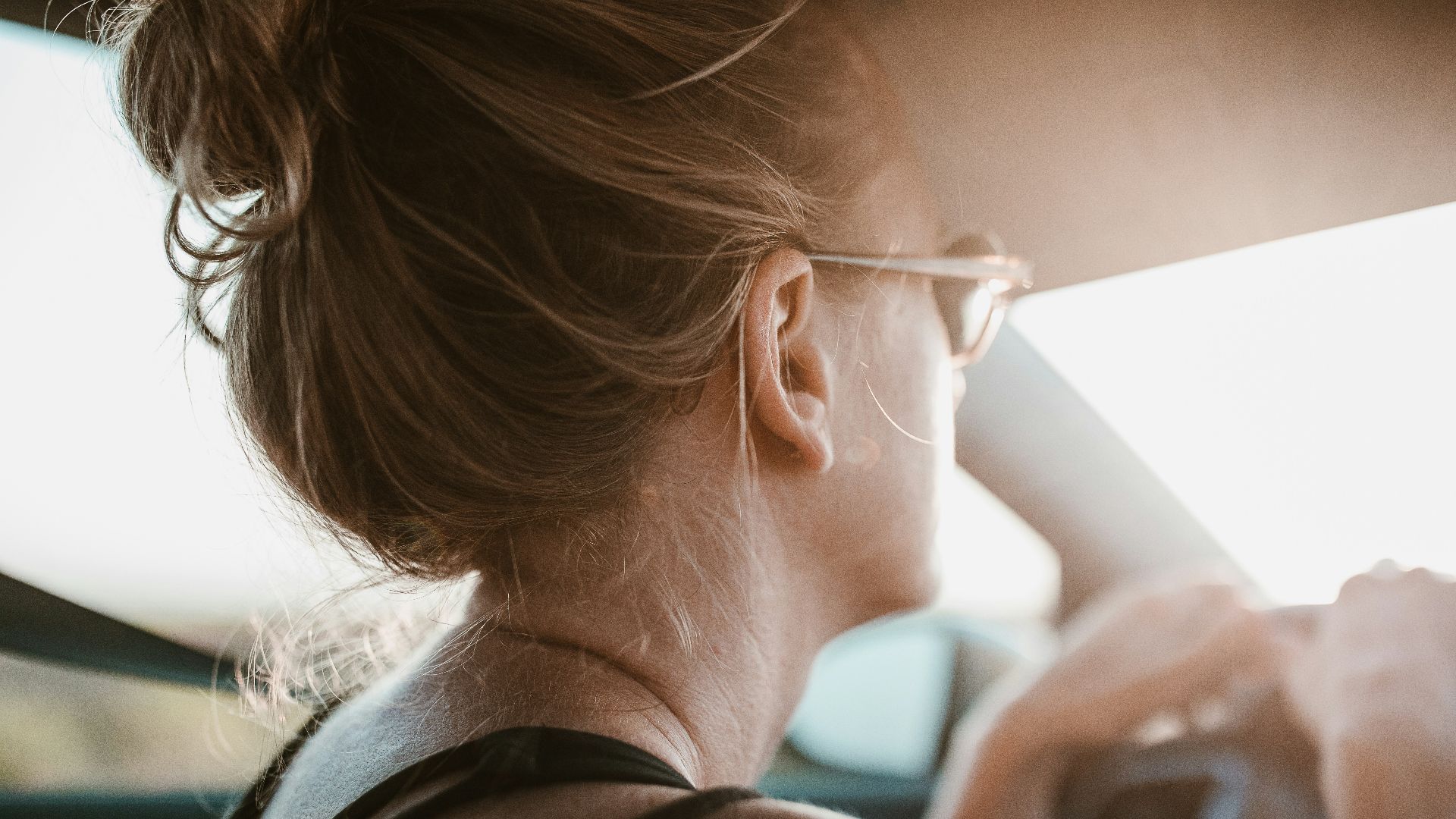 woman holding steering wheel inside vehicle