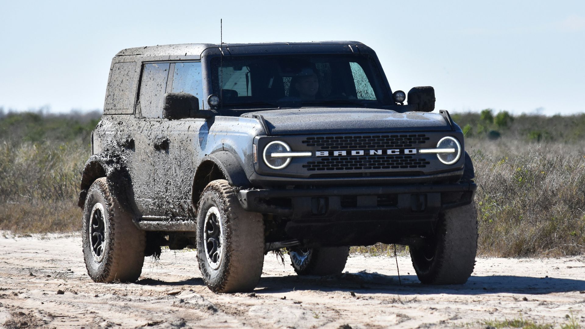 a black truck parked on a dirt road