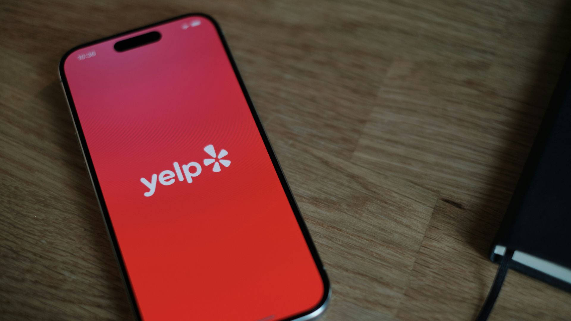 A cell phone sitting on top of a wooden table