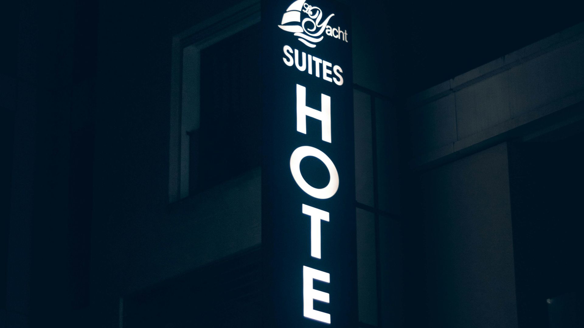 a hotel sign lit up in the dark