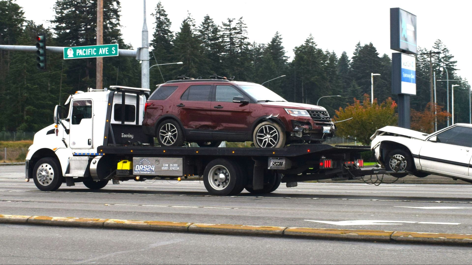 A tow truck towing a car on a flatbed