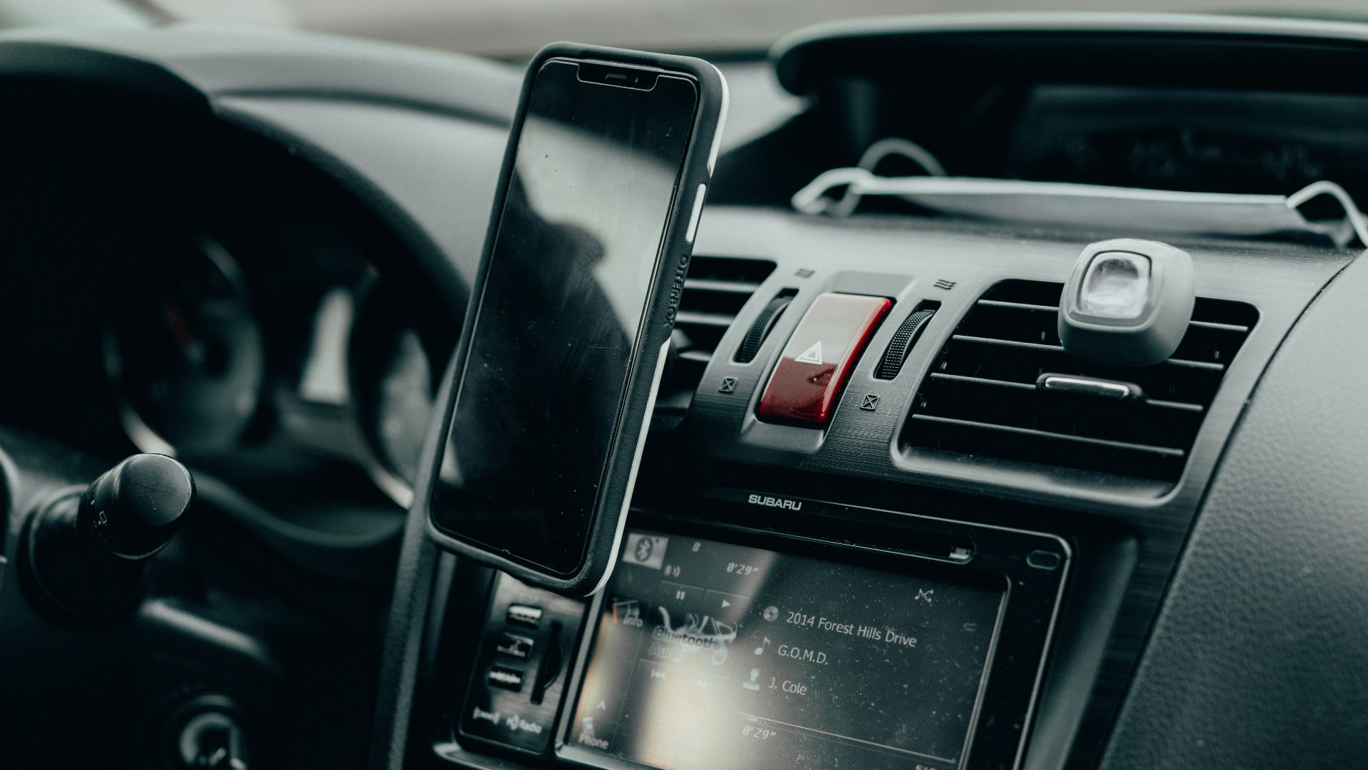black iphone 4 on car center console