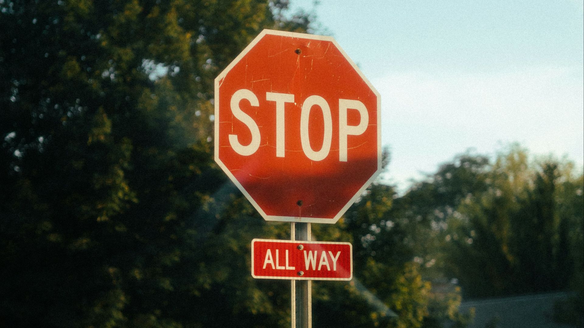 a red stop sign sitting on the side of a road