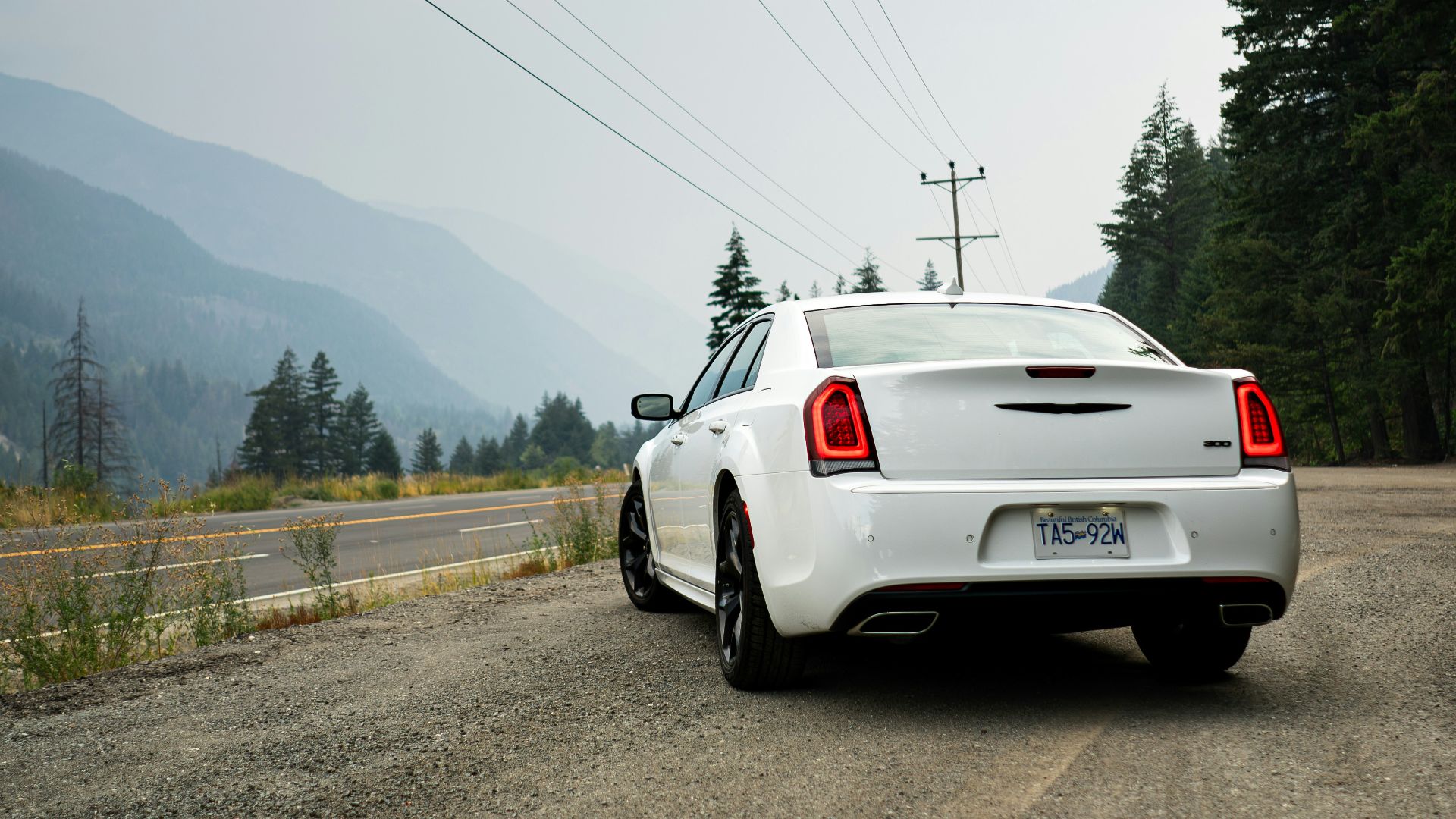 A white car is parked on the side of the road