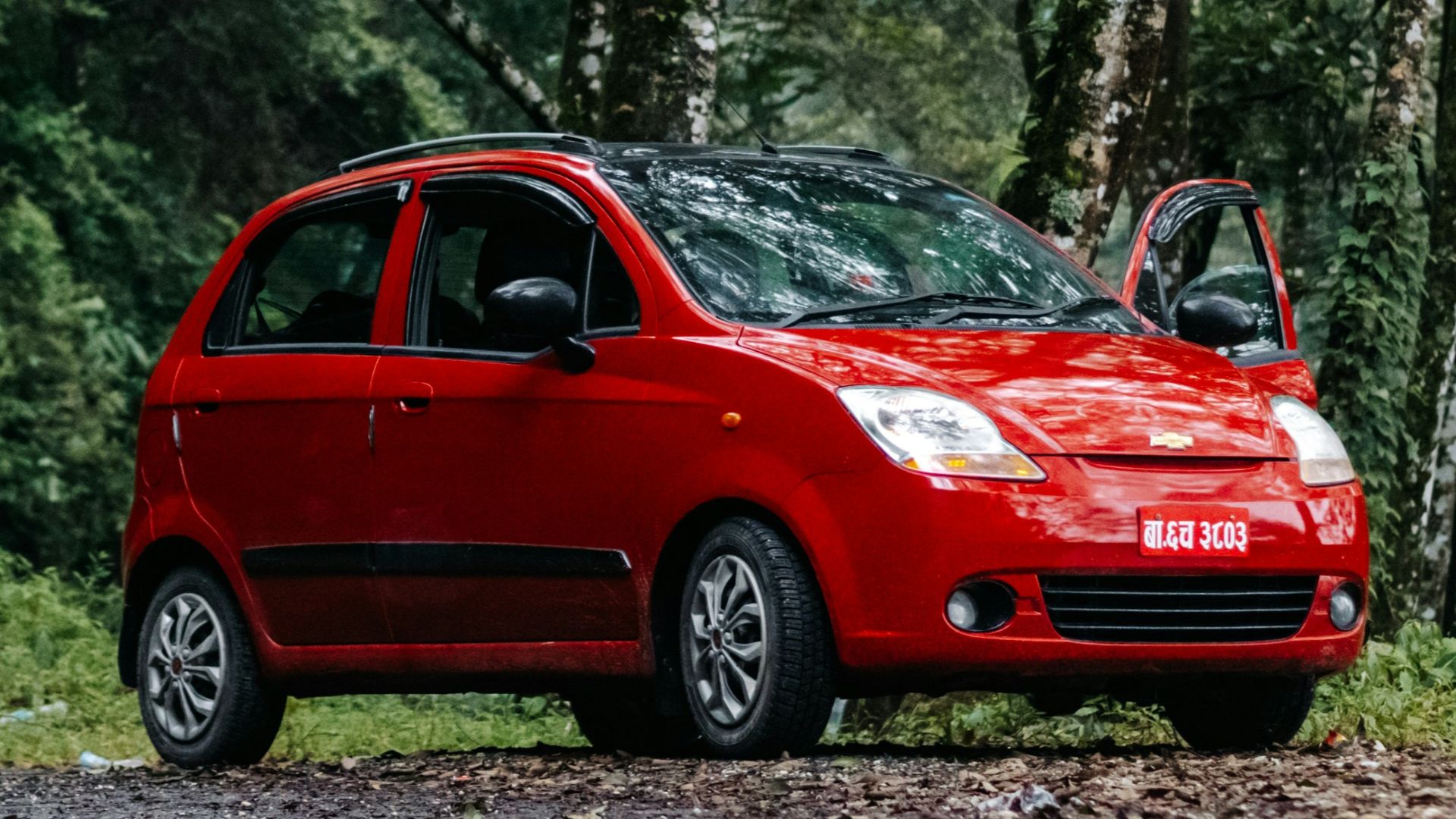 a small red car parked on the side of a road